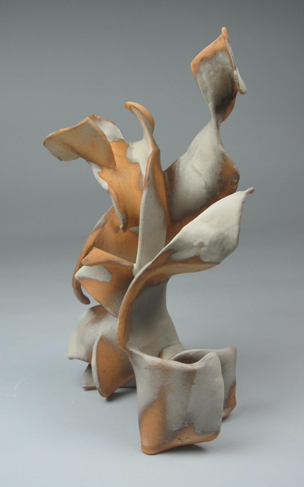 Sara Fine-Wilsons ”Flicker” is a gestural 18 x 12 x 8 inch ceramic sculpture in pale cream with accents of warm sepia, and grey. In this graceful and evocative sculpture individual slab elements are assembled, layered in glaze in some areas, left