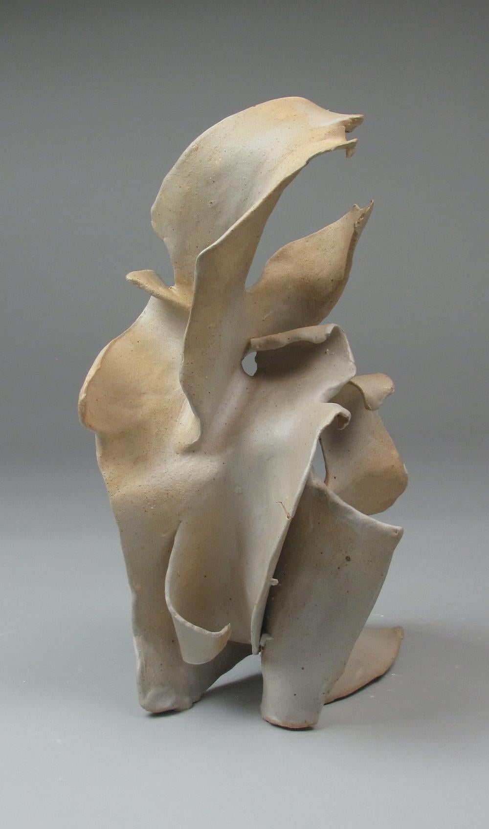 Sara Fine-Wilsons “Rustic” is a gestural 15 x 8 x 7 inch ceramic sculpture in pale cream, light gray and white with iron speckles. In this graceful and evocative sculpture individual slab elements are assembled, layered in glaze in areas while other