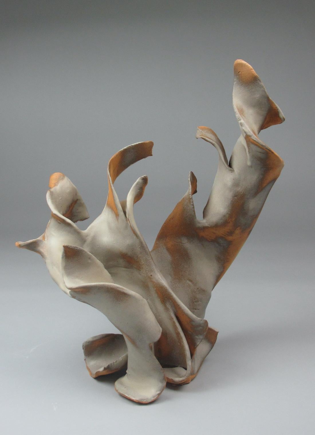 Sara Fine-Wilsons “Sway” is a gestural 17.5 x 14 x 9 inch ceramic sculpture in pale cream with accents of warm sepia, and grey. In this graceful and evocative sculpture individual slab elements are assembled, layered in glaze in areas while other