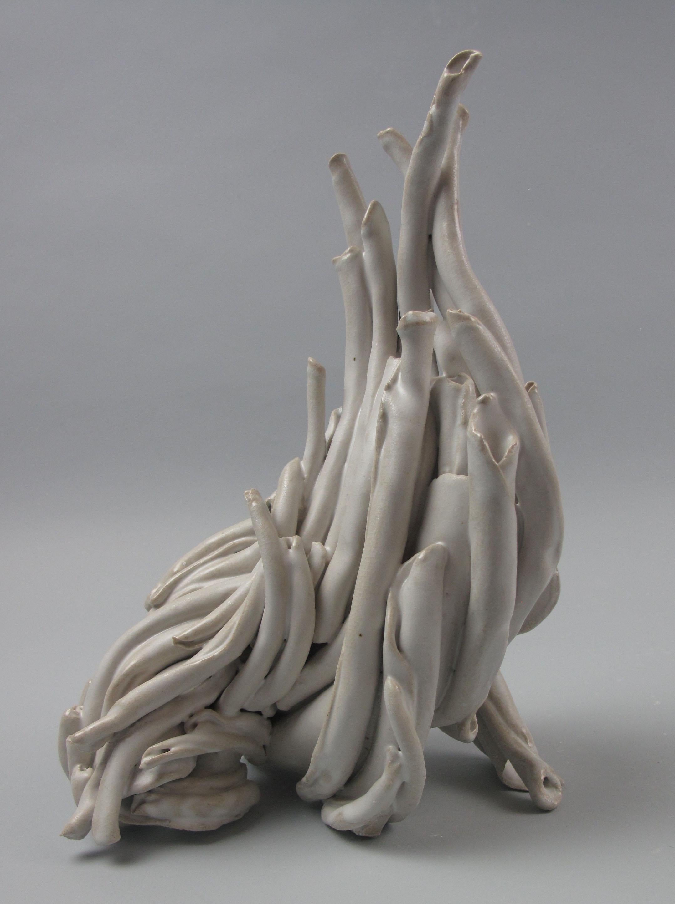 Sara Fine-Wilsons ”Turn” is a gestural 10.5 x 8 x 6.5 inch ceramic sculpture in cream and white. In this graceful and evocative sculpture individual twisted elements are assembled and layered in glaze. This process emphasizes the smooth fluid