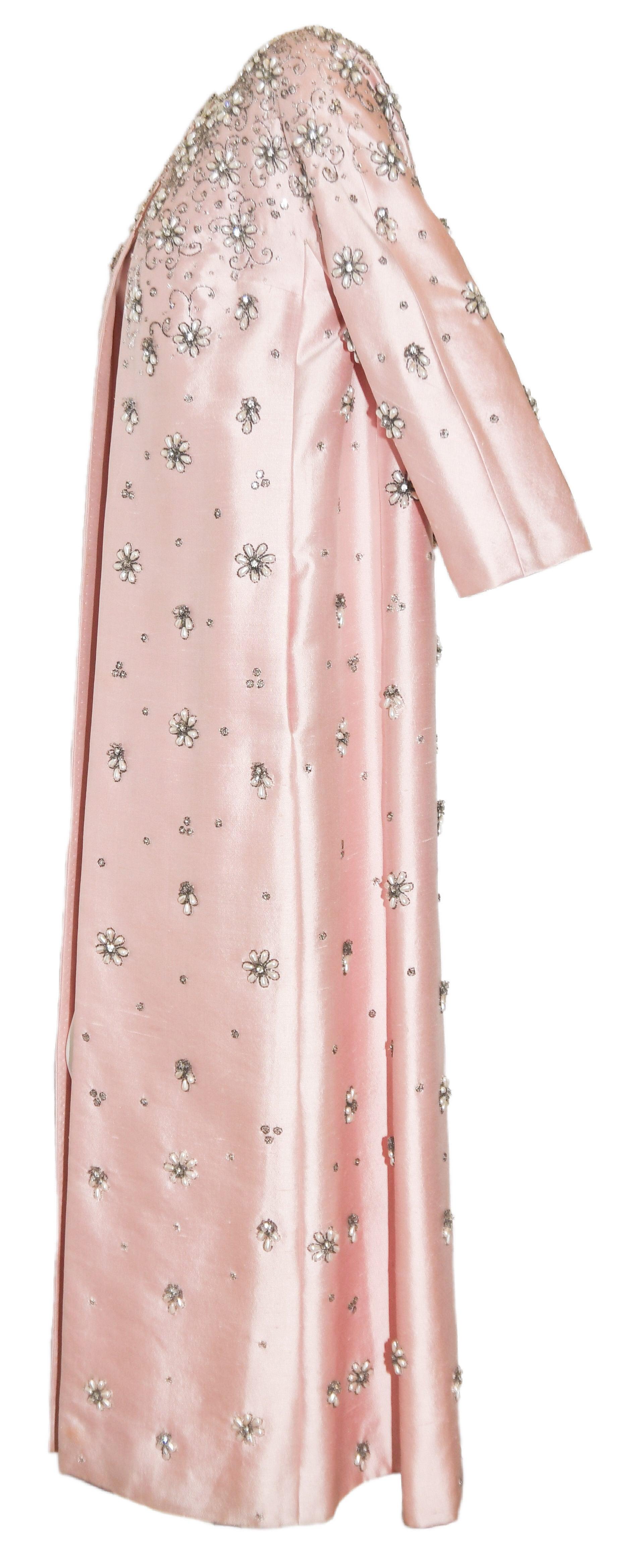 Sara Fredericks vintage from the 1960's is heavily beaded with faux teardrop pearls, tube beads and iridescent crystals and sequins.  This pink silk long evening coat is covered in Daisy like flowers, commencing from the round neckline cascading