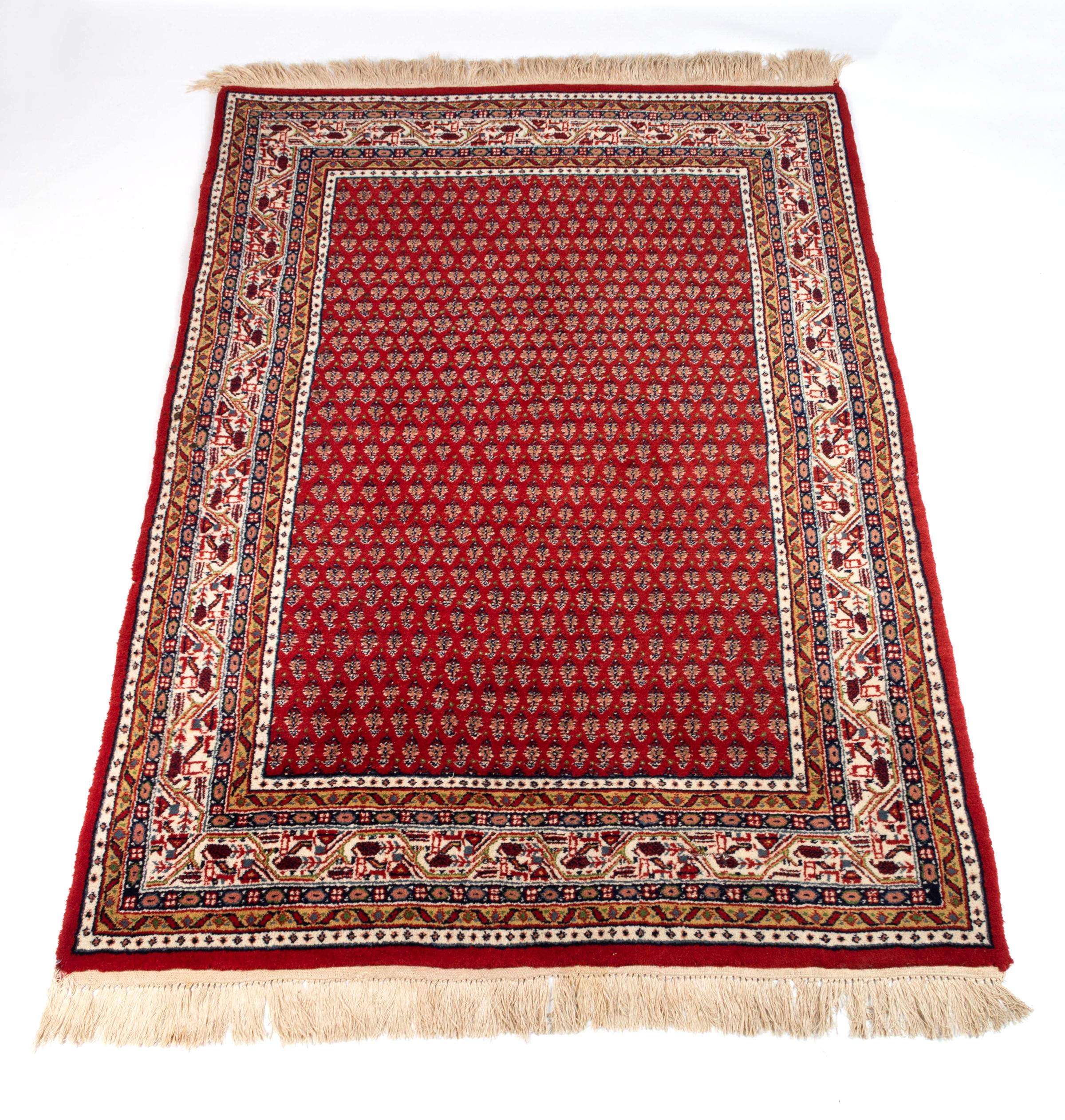 A Saraband rug, West Persia, the rust field with overall diagonal rows of floral boteh motifs in an ivory angular flowering vine border between floral and plain stripes.

Circa 1980.

Approx. 180cm x 123cm

Condition Report: Apart from tiny