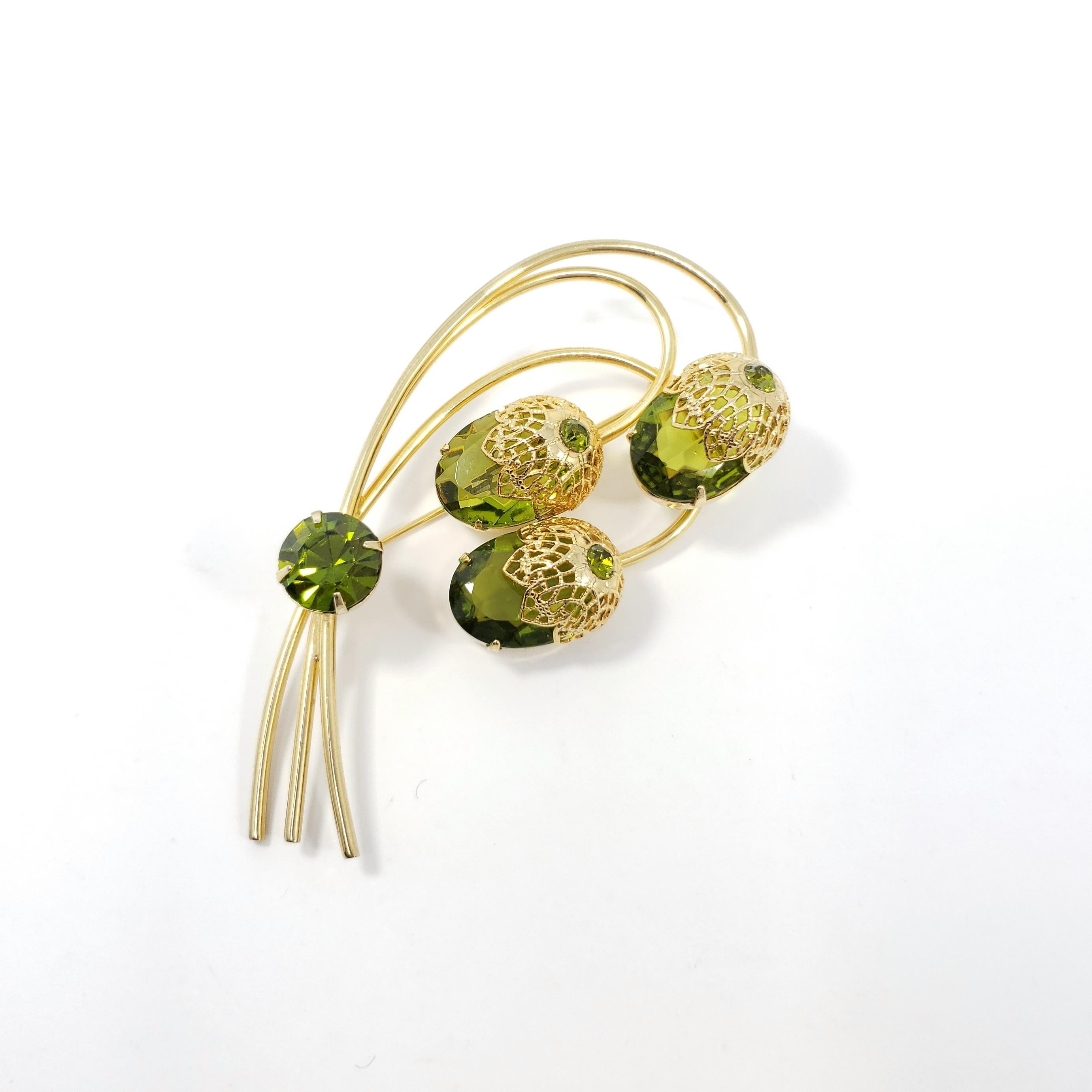 Golden Sarah Coventry pin brooch, featuring olivine crystal acorns on a stylized branch.

Gold-plated.

Marks / hallmarks: Sarah Cov