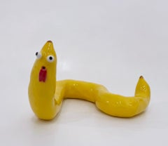 Banana Worm (2021), Glazed ceramic fruit sculpture with face