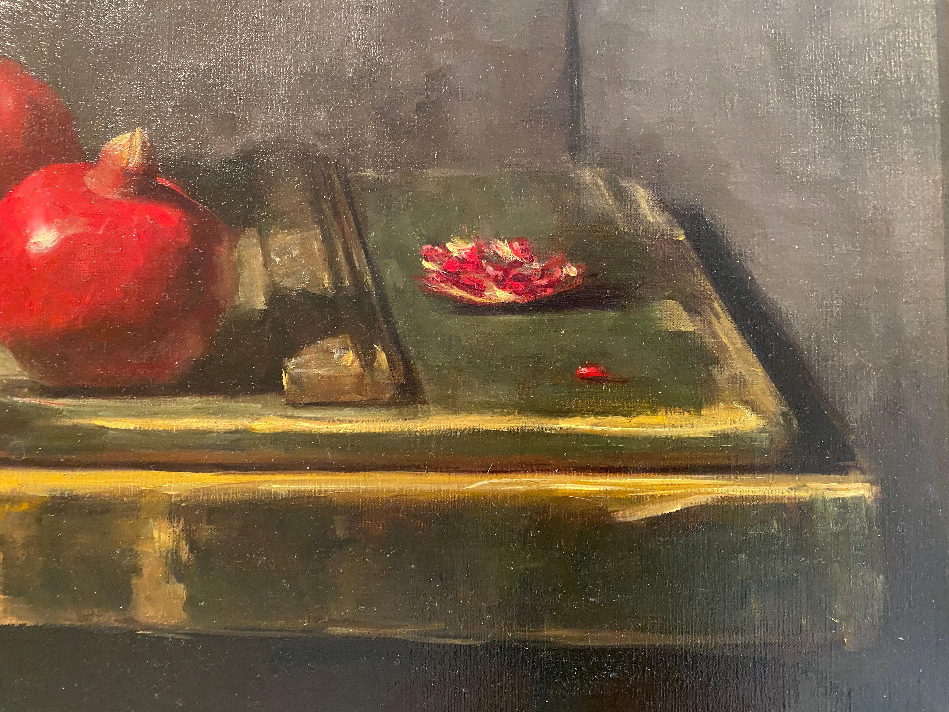 A Still life painting of a bright red pomegranates scattered about; in a brass bowl, on a rustic wooden table, sliced. 

Framed dimensions: 26 x 39 inches

Sarah Lamb is a talented and dynamic realist painter. With classical skill—and through