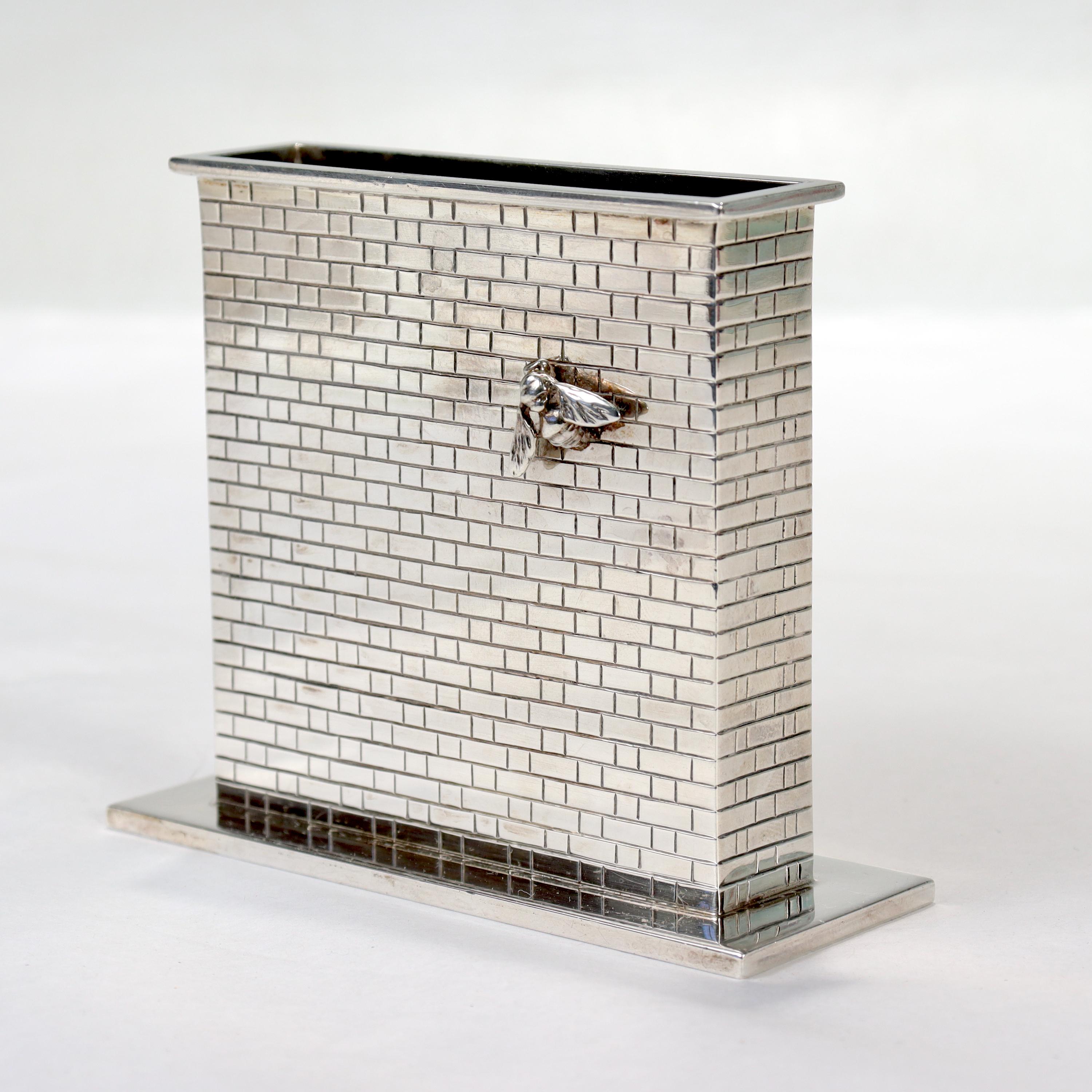 A fine, unique hand made vase or vessel 

By Sarah Jones.

In sterling silver. 

Exhibited in the Exhibition entitled: Sayings in Silver

In the form of a brick wall with an applied figural wasp or bee to both sides.

Sarah Wall Jones was one of