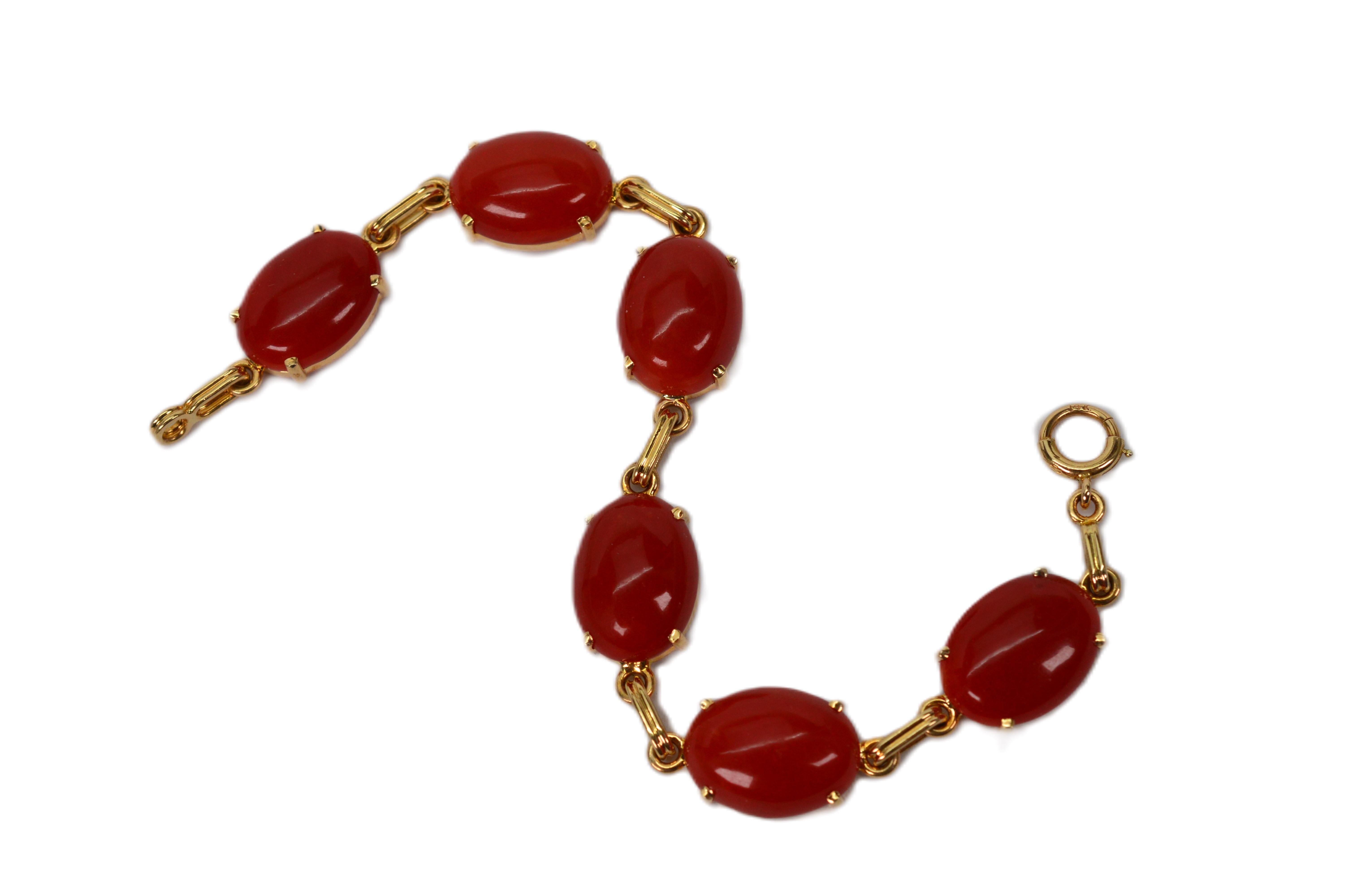 Warm natural Sardinian Coral cabochons set in bright 14 Karat yellow gold frames are prominently featured on this vintage link bracelet.  Known as the red gold of the Mediterranean Sea, Sardinian coral has been harvested for many thousands of years