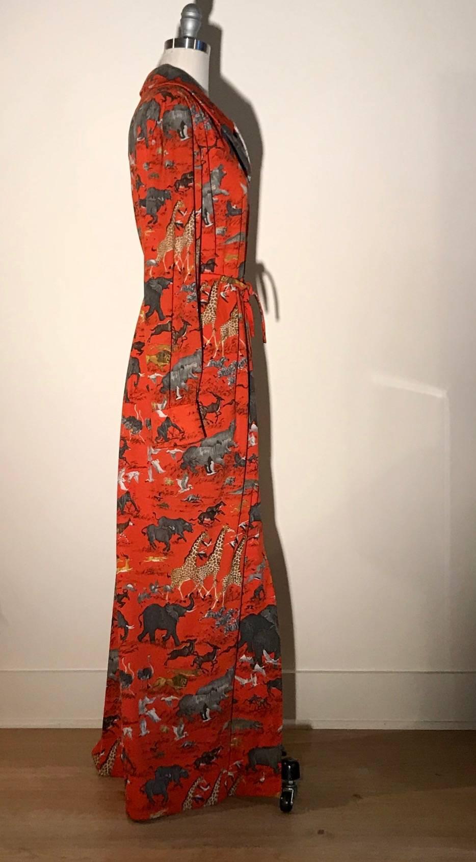 Vintage red maxi length shirt dress by Ferdinando Sarmi New York with all over safari print, featuring elephants, rhinos, giraffes, gazelles, and more. Includes narrow belt in same fabric (not attached.) Hidden zipper at front center. Three hidden