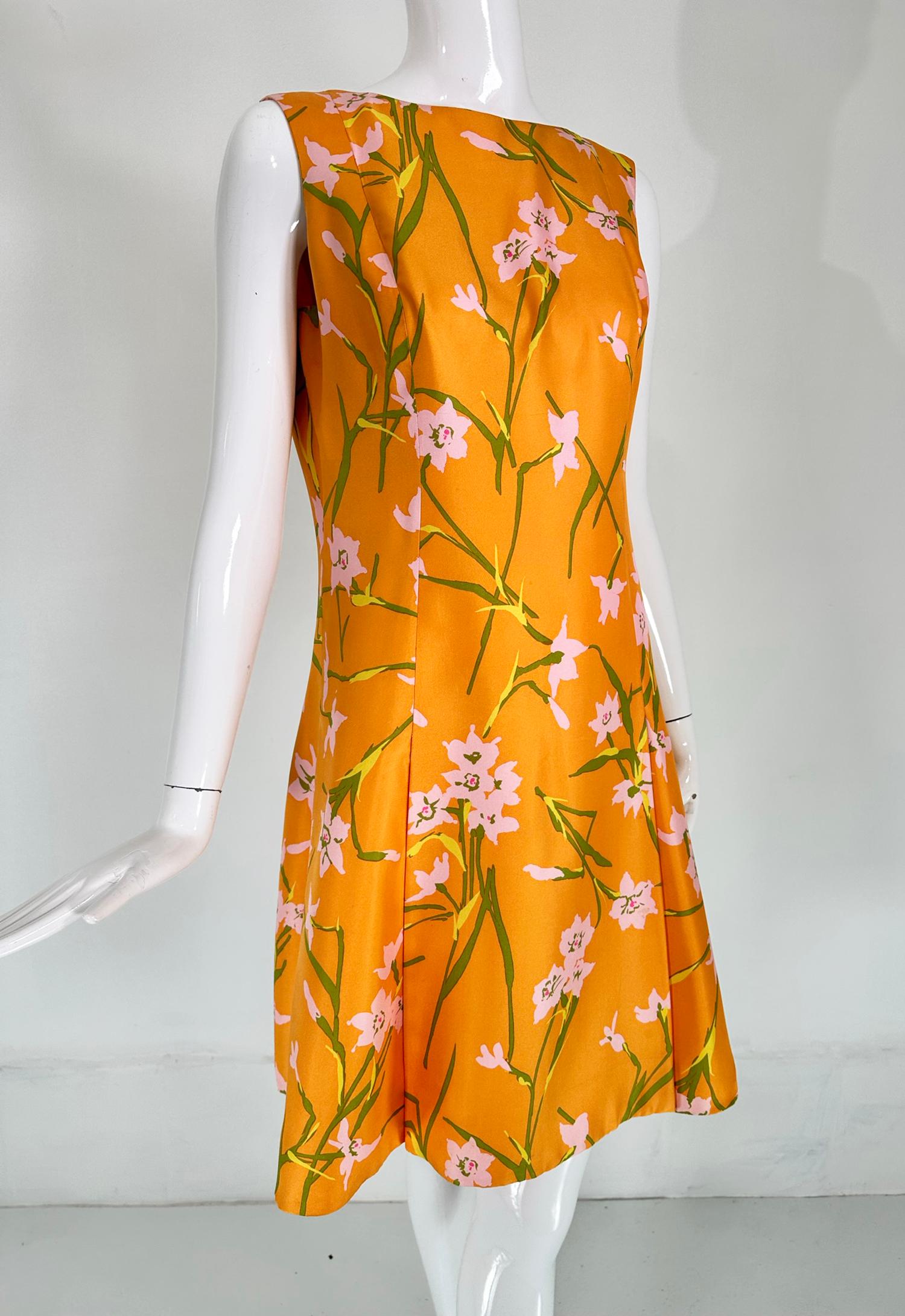 Sarmi orange floral printed silk, inverted pleat skirt sleeveless dress from the 1960s. Beautiful silk dress with a jewel neckline, sleeveless with princess seams, the dress has inverted pleats at the lower skirt front and back. The print is orange