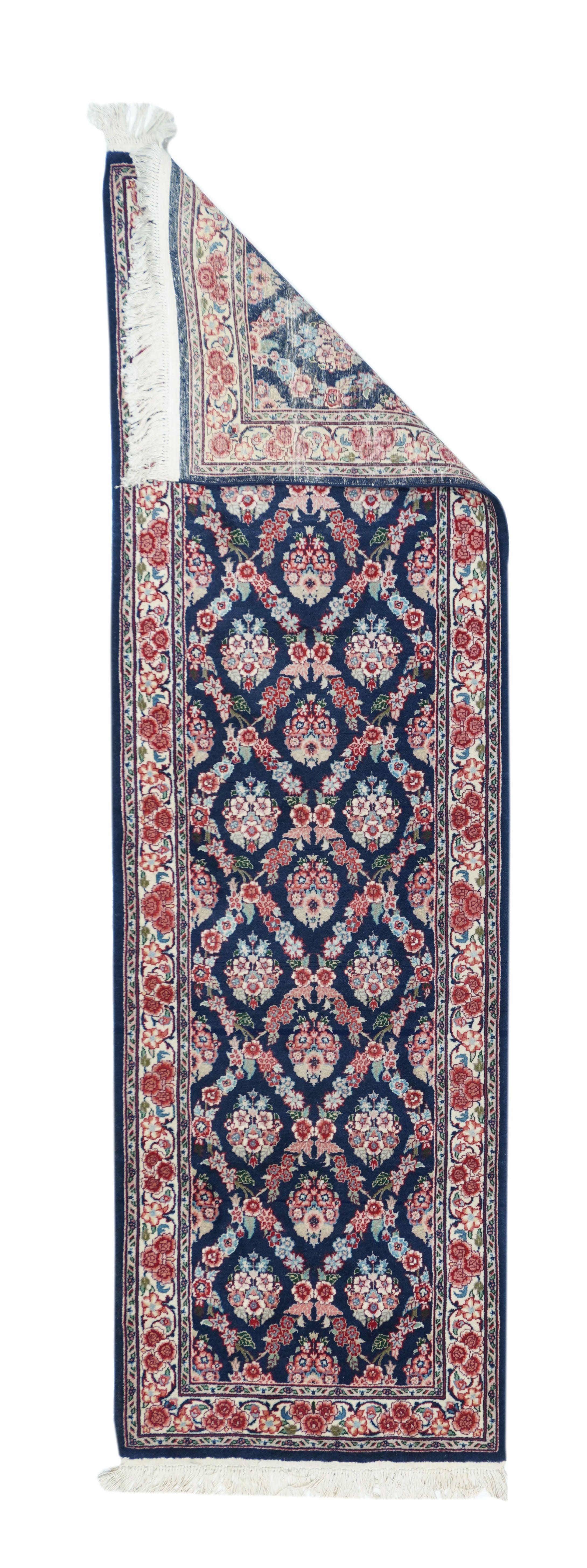 Sarouk Runner 2'6'' x 8'0''. Il fondo navy è sezionato da un reticolo floreale e ogni riserva definita mostra una palmetta a rosette multiple. I toni accesi includono: rosso, rosso rosato, paglia, blu chiaro, verde chiaro, ecru e rosso scuro. Bordo