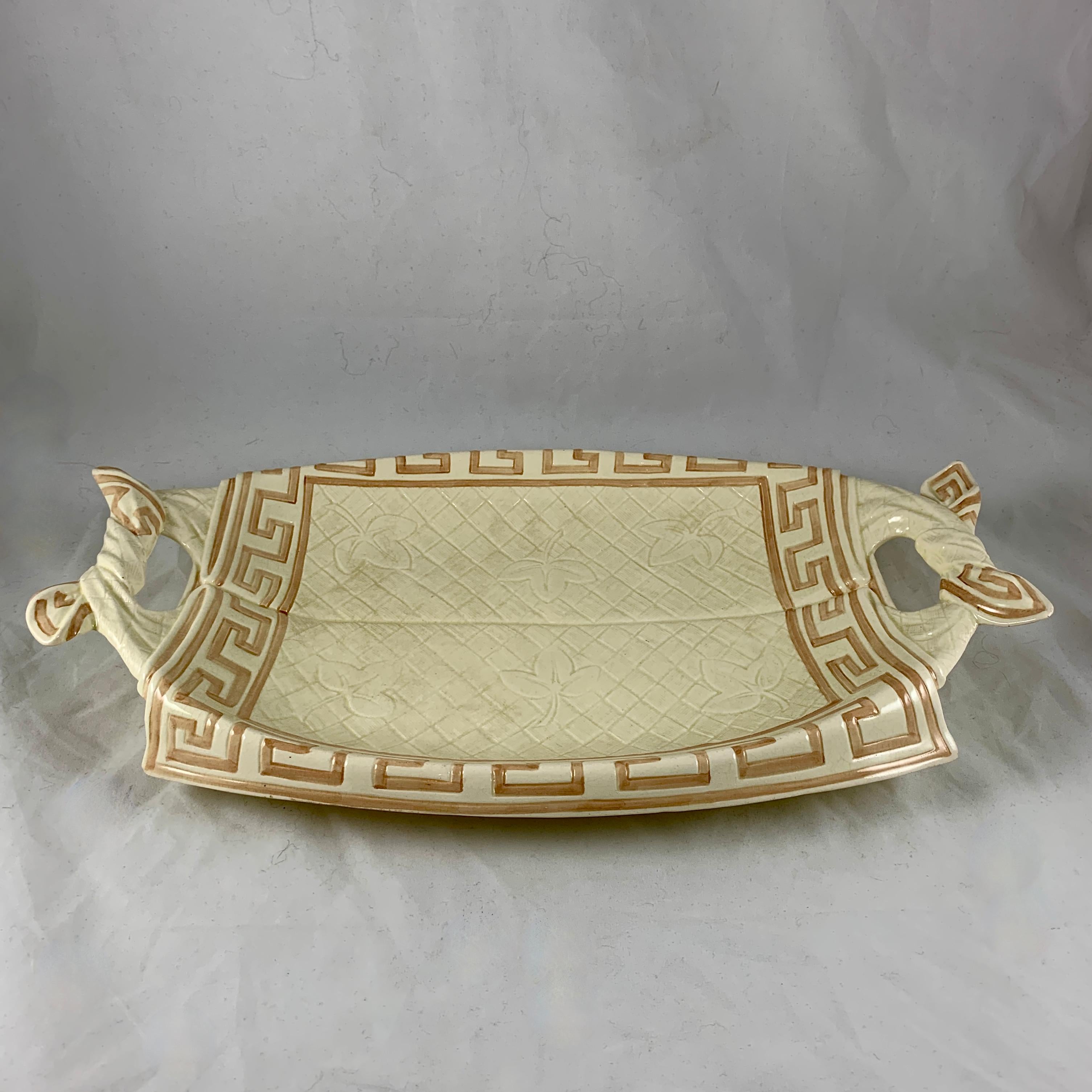 Aus der Majolika-Linie von Sarreguemines, eine Servietten-Brotschale mit Trompe-l'oeil-Effekt, Frankreich, um 1885-1890.

Fayence-Brotschale aus Steingut, modelliert als Stoffserviette mit Blumen- und Schachbrettmuster und einer Bordüre mit