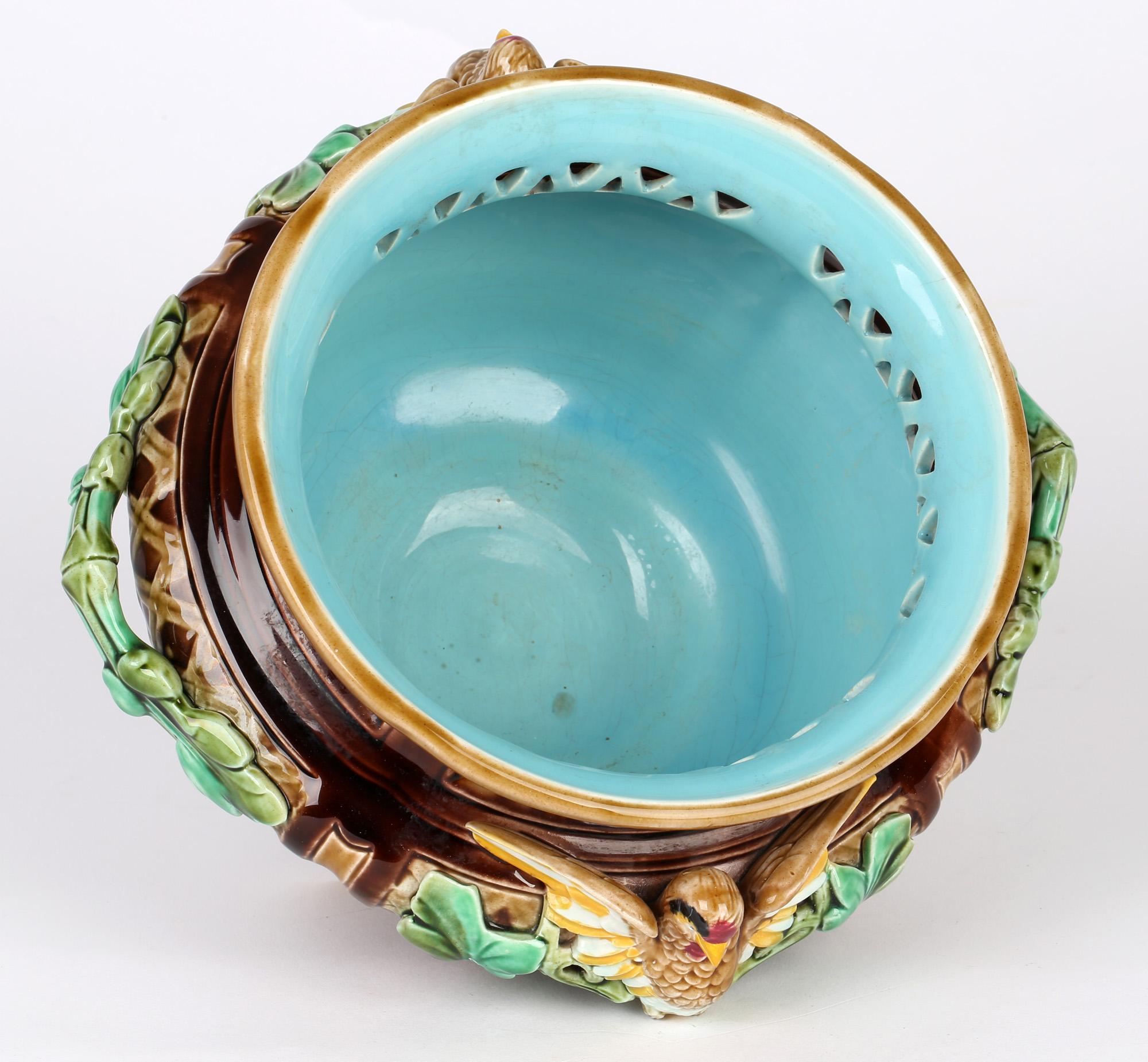 A rare and stunning French majolica twin handled pottery bowl applied with birds by renowned maker Sarreguemines and dating from the latter 19th century. The rounded bowl stands raised on four half ball shaped feet with a basket weave styled design.