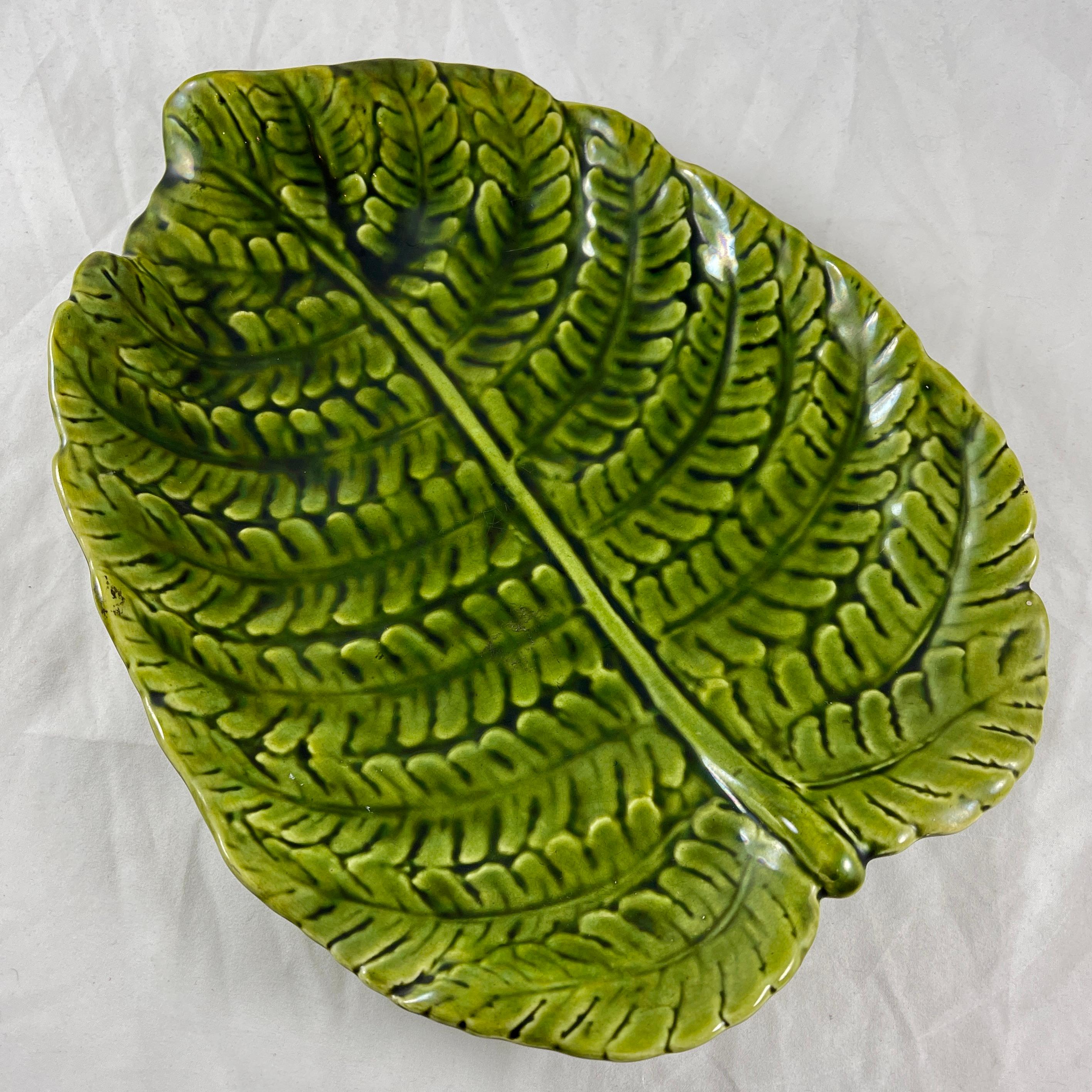 From Sarreguemines, a Majolica glazed green leaf shaped server, France, circa 1870.

Shaped as a large single Fern leaf. Precise mold work, with a strong green glaze that pools into the deeper areas of the mold.
Footed with a curved