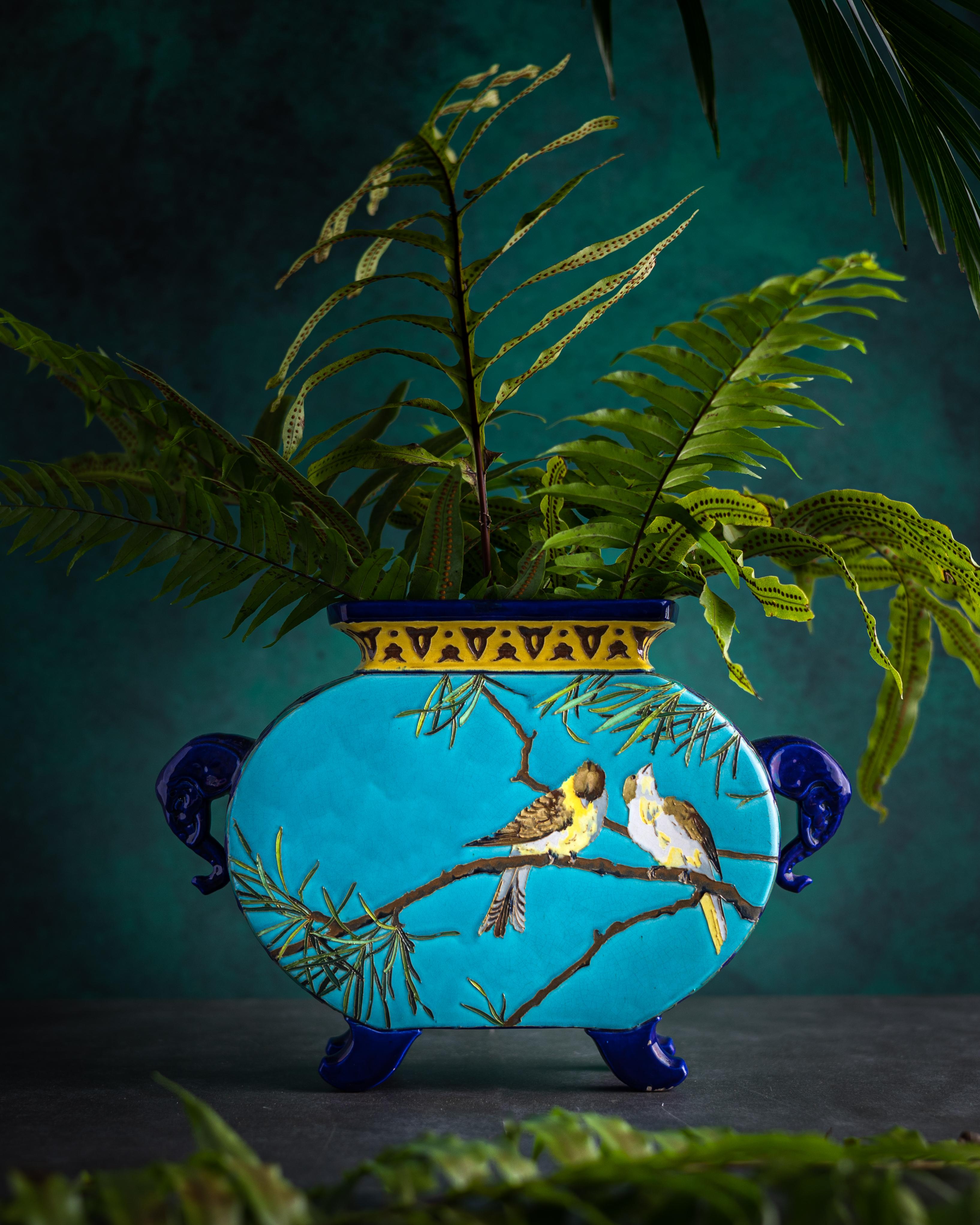 A gorgeous turquoise blue Majolica jardiniere made by the French manufactory Sarreguemines circa 1880-1890. The jardiniere is decorated in the eclectic Japonisme-style with beautifully hand-painted birds among pine branches, faux cloisonne, and