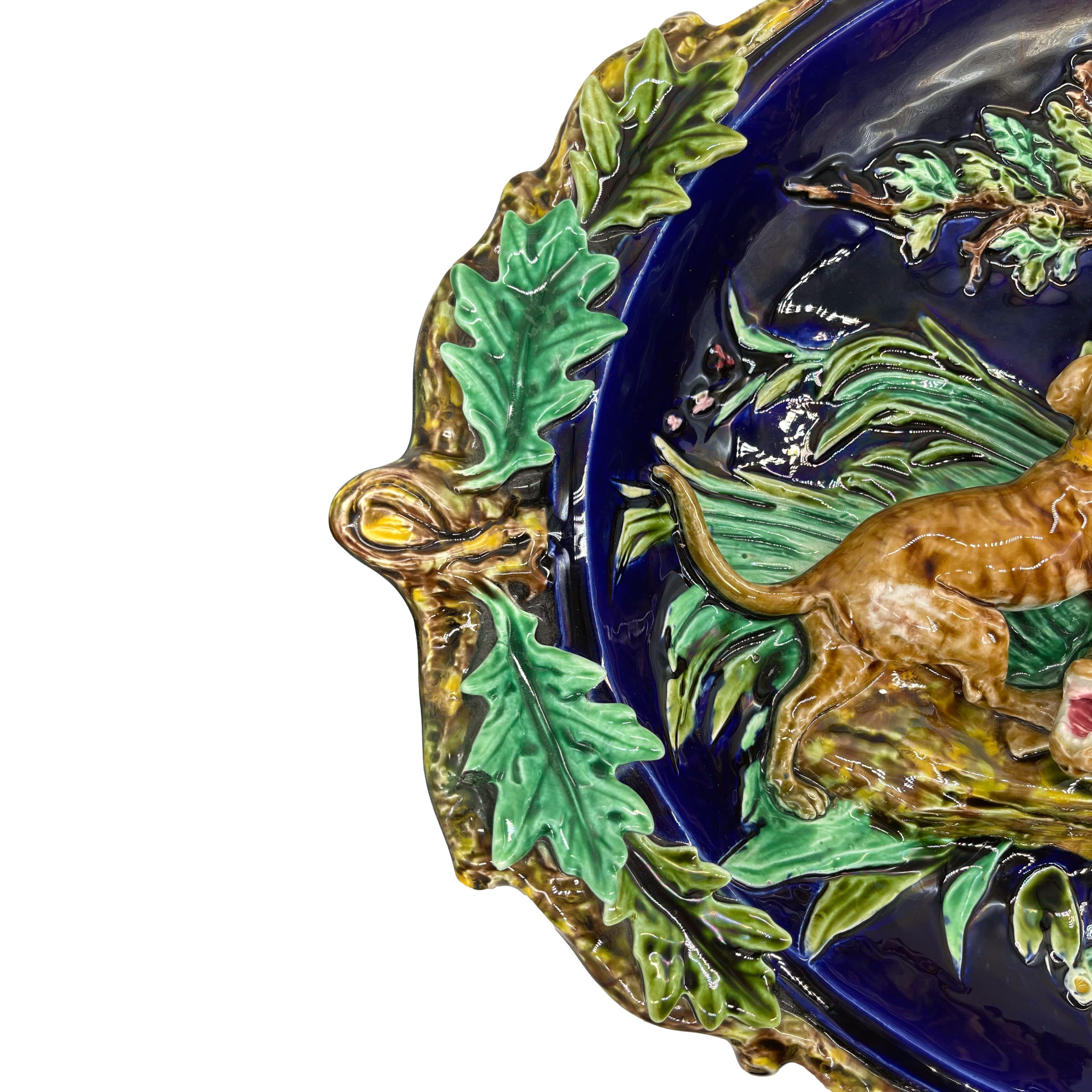 Sarreguemines Barbotine (French majolica) Monumental Trompe l'oeil Game Plaque, the relief-molded concave platter with applied hunting hounds and a wolf in a violent struggle in a woodland setting, with branch-form rim terminating in knots which