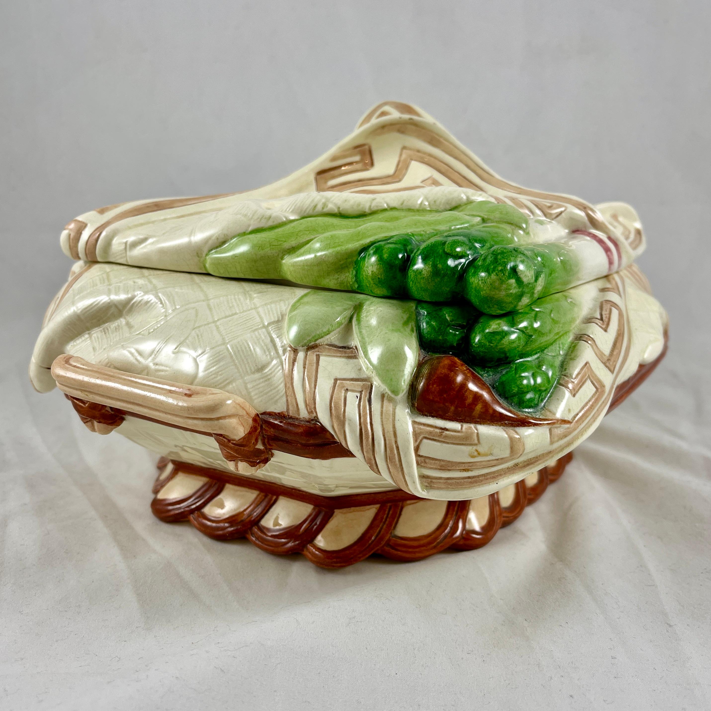 From Sarreguemines, France, a very scarce majolica glazed covered tureen, circa 1870.

A basket and napkin form covered tureen modeled in the Trompe L’oeil style. The base is molded as a woven basket with two side handles. A ‘cloth’ napkin