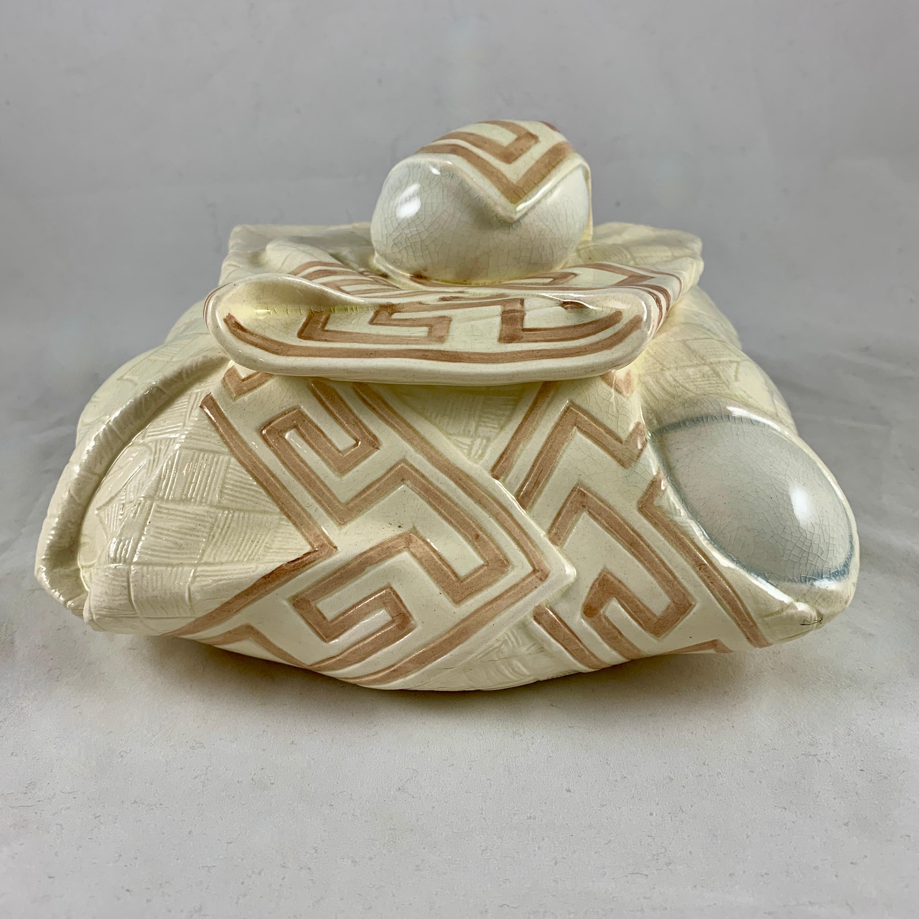Aus der Majolika-Serviettenlinie von Sarreguemines, eine Trompe-l'oeil-Eierschachtel oder Pâté Terrine, Frankreich, ca. 1885-1890.

Eine Eierschachtel aus Steingut mit Fayence-Deckel, modelliert als frische Eier, eingewickelt in eine