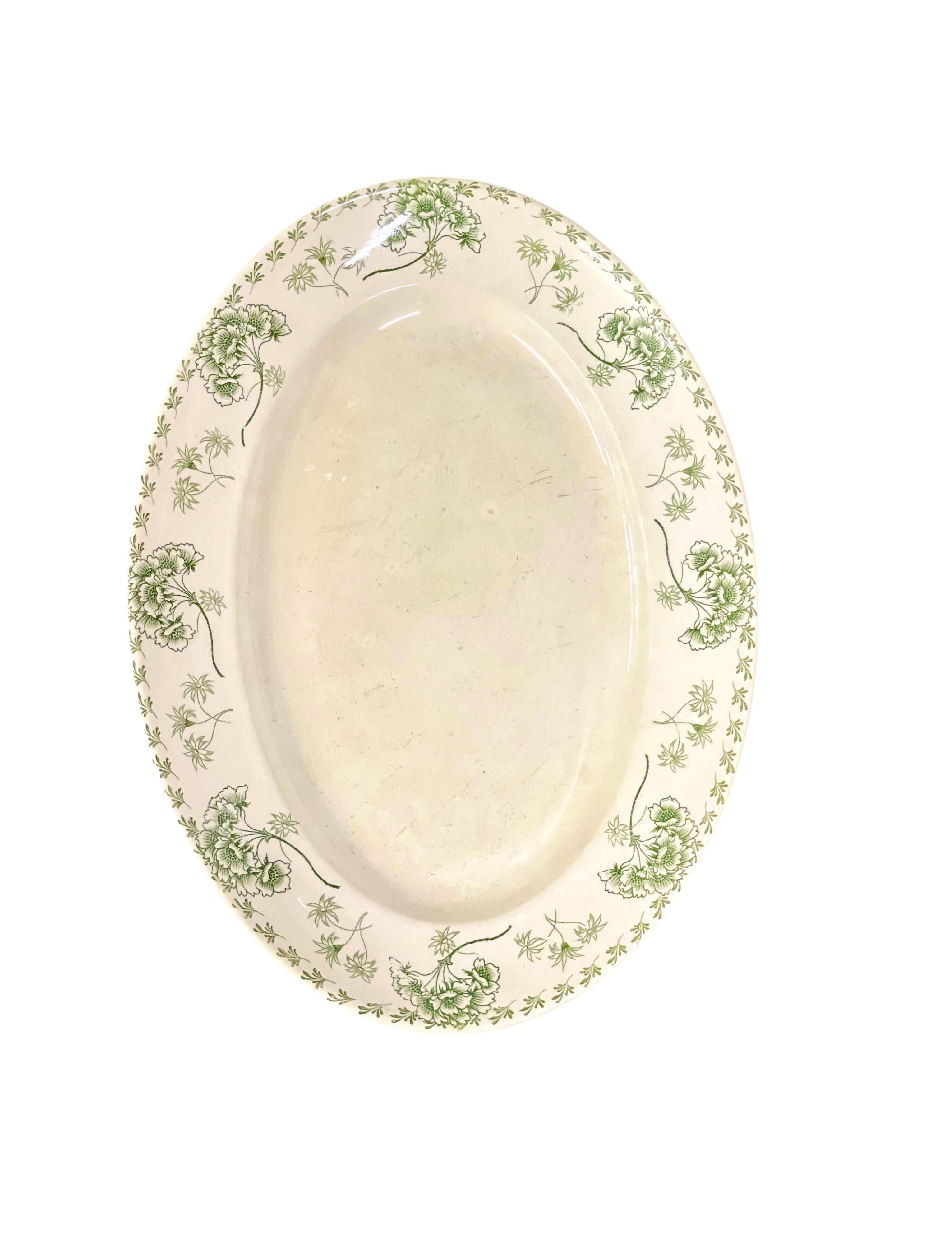 Esta encantadora vajilla antigua francesa de Sarreguemines, modelo Palmyre, presenta un delicado dibujo floral verde transferido sobre cerámica blanca cremosa. Fabricado a finales del siglo XIX, este conjunto capta maravillosamente la elegancia y el