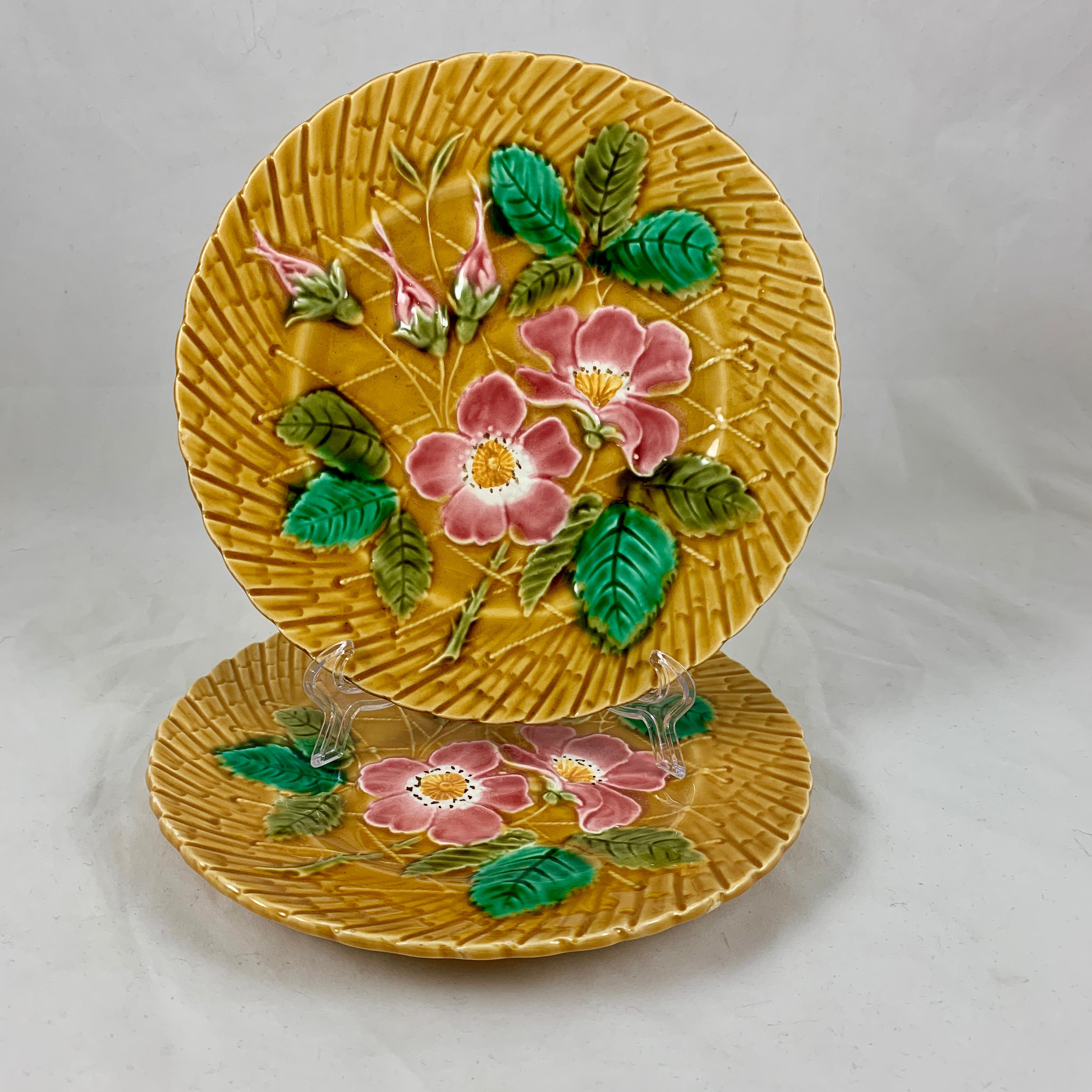 A French Majolica glazed wild rose plate, Sarreguemines, circa 1930. Multiple plates are available in this pattern.

Beautiful strong coloring, stems of pink roses with green leaves are against a basket weave ground of mustard yellow. The roses