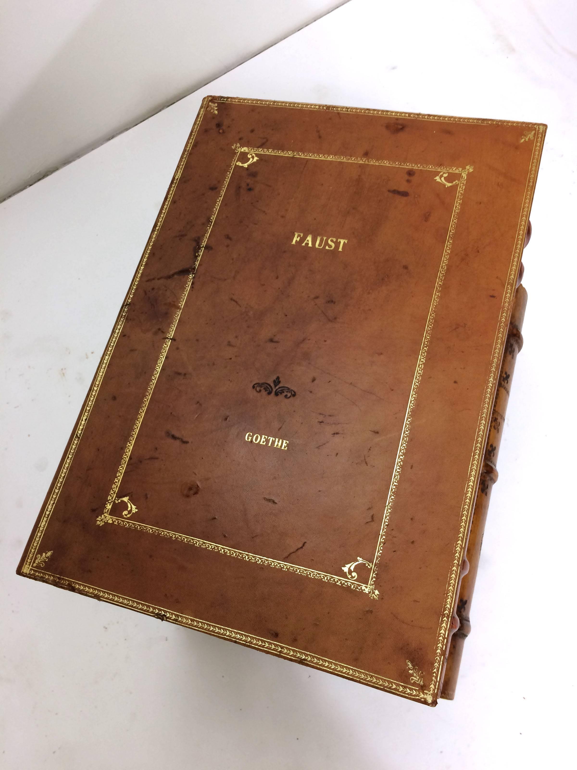 End table in the form of a stack of leather bound antique books including Goethe's Faust as the top layer, and including other volumes by Dante and Byron. In genuine bound leather and gilt paint over wood, it features an interior storage trunk and