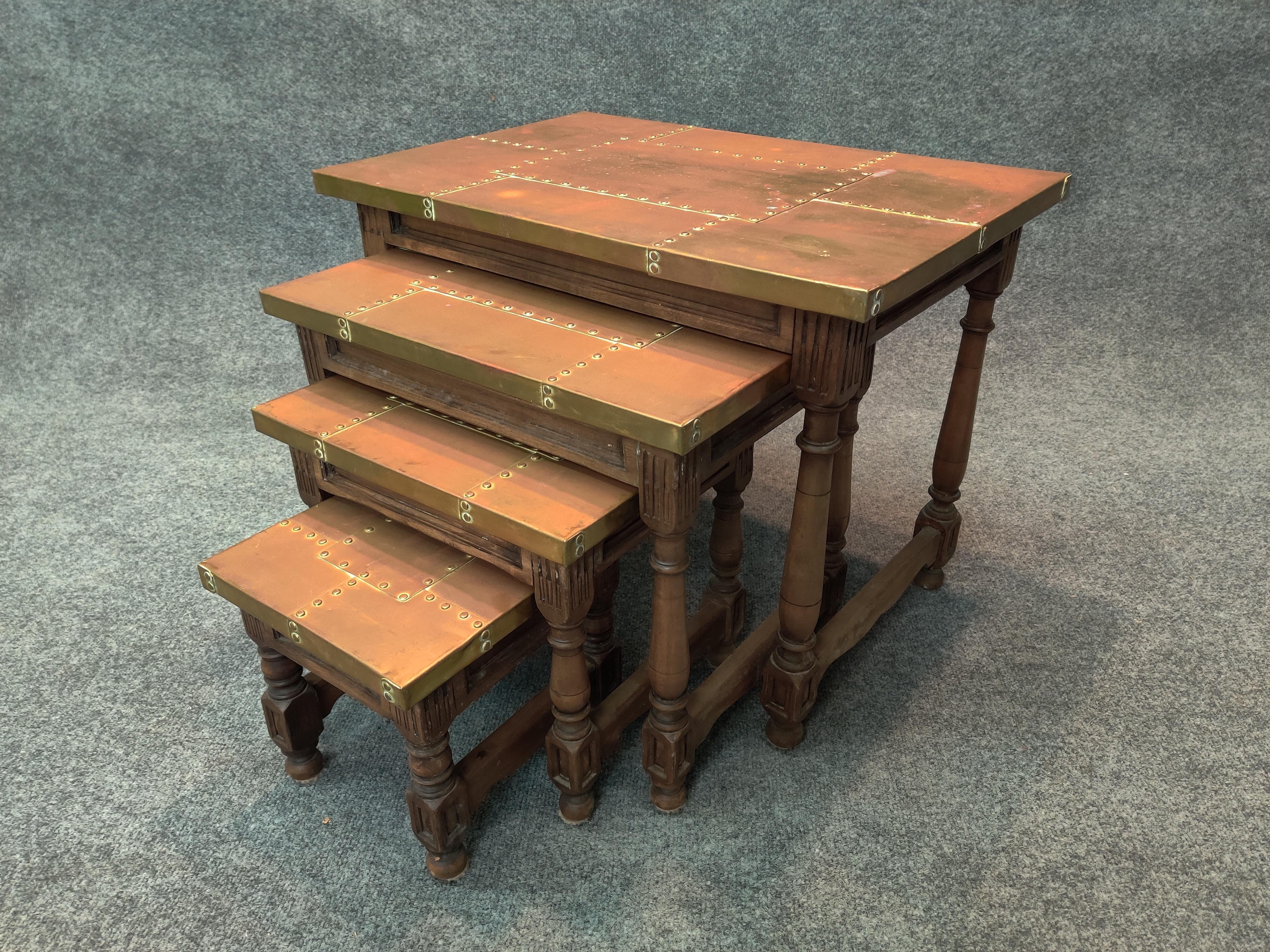 Set of 4 campaign style vintage and authentic Sarreid, Ltd rare nesting tables. Heavily riveted brass over wood tops mounted on intricately carved solid wood legs. Some oxidation to original brass finish. Also, shallow minor dings and dents to each.