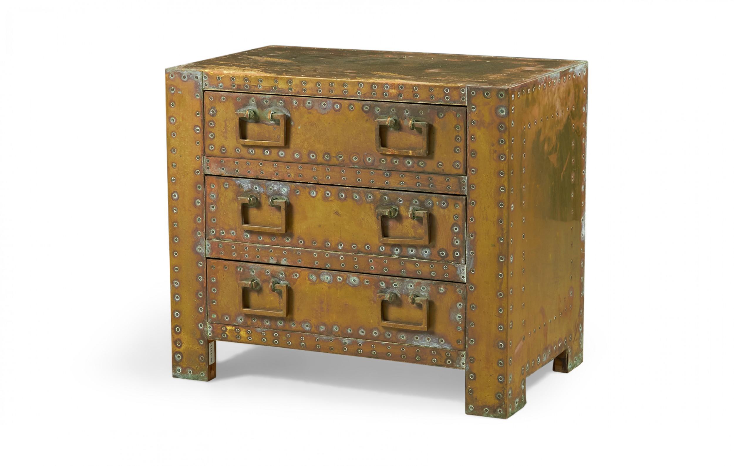 Spanish High Style 'Strongbox' bedside table / commode with brass-clad exterior with natural patina, copper studs, and three drawers with rectangular brass pulls. (SARREID, LTD.) (Similar pieces available with different patinas: DUF0025B-D, similar