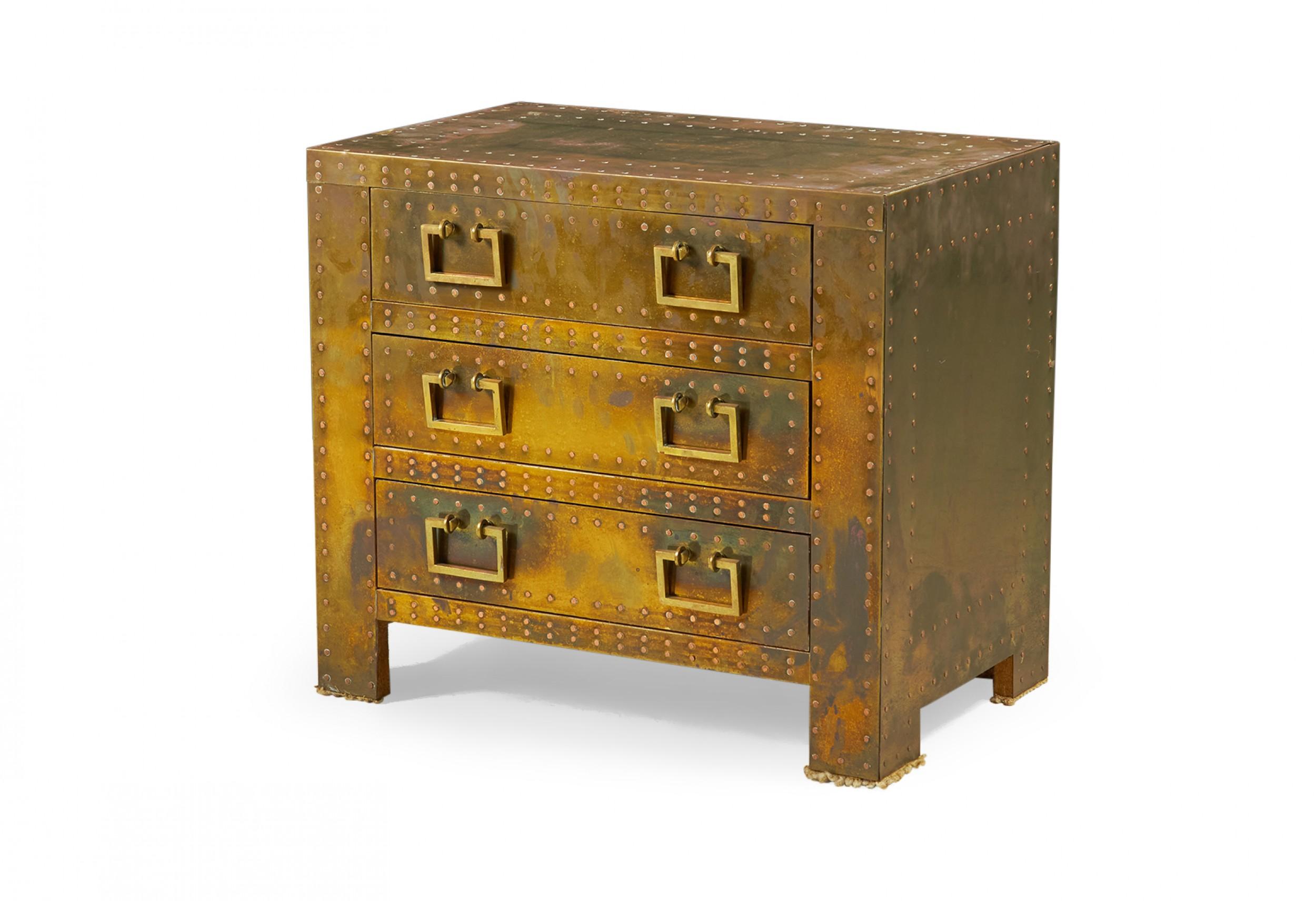 Spanish High Style 'Strongbox' bedside table / commode with brass-clad exterior with natural patina, copper studs, and three drawers with rectangular brass pulls. (SARREID, LTD.)(Similar pieces available with different patinas: DUF0025A-D, similar