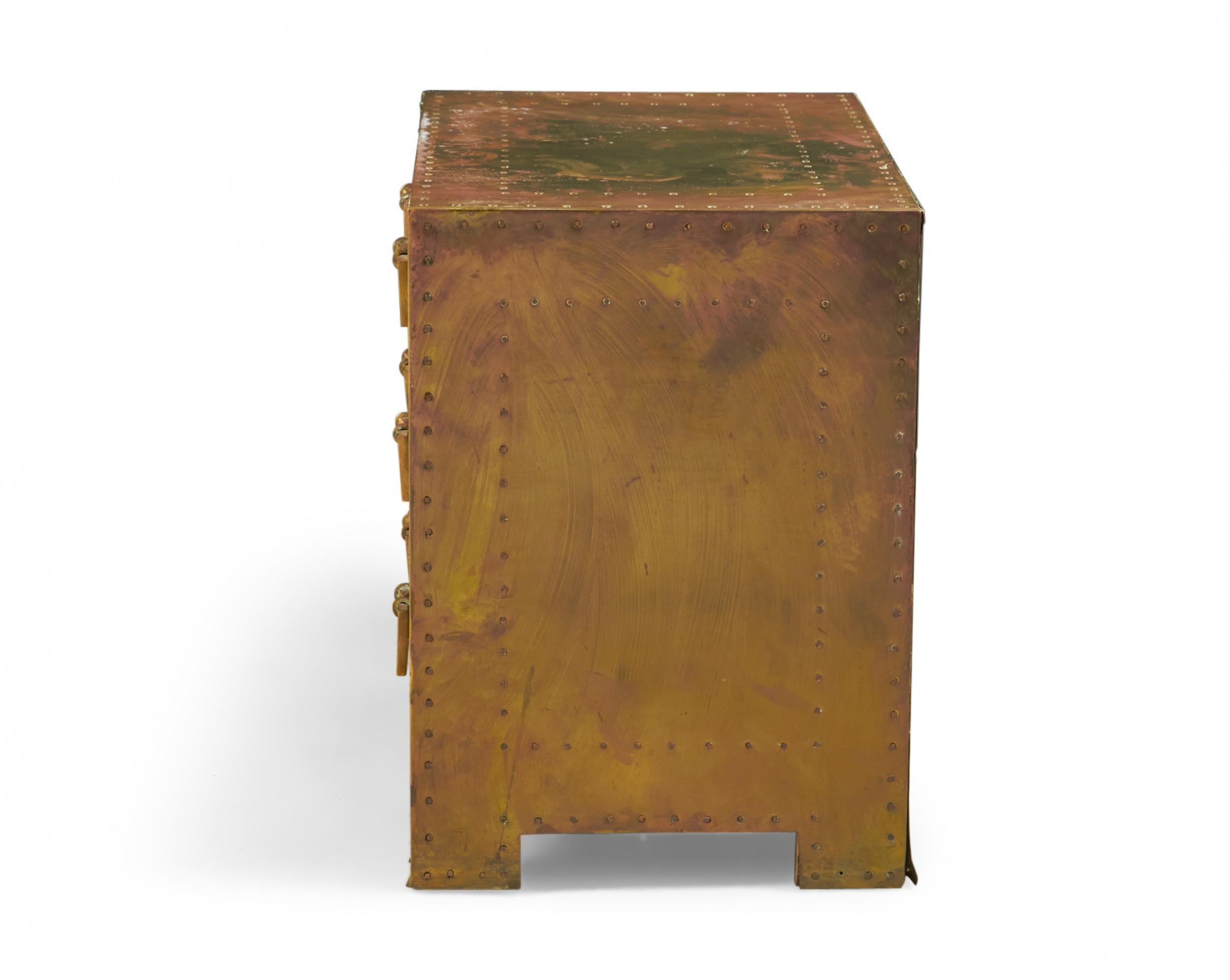 Spanish high style 'Strongbox' bedside table / commode with brass-clad exterior with natural patina, copper studs, and three drawers with rectangular brass pulls. (SARREID, LTD.)(Similar pieces available with different patinas: DUF0025A-D, similar