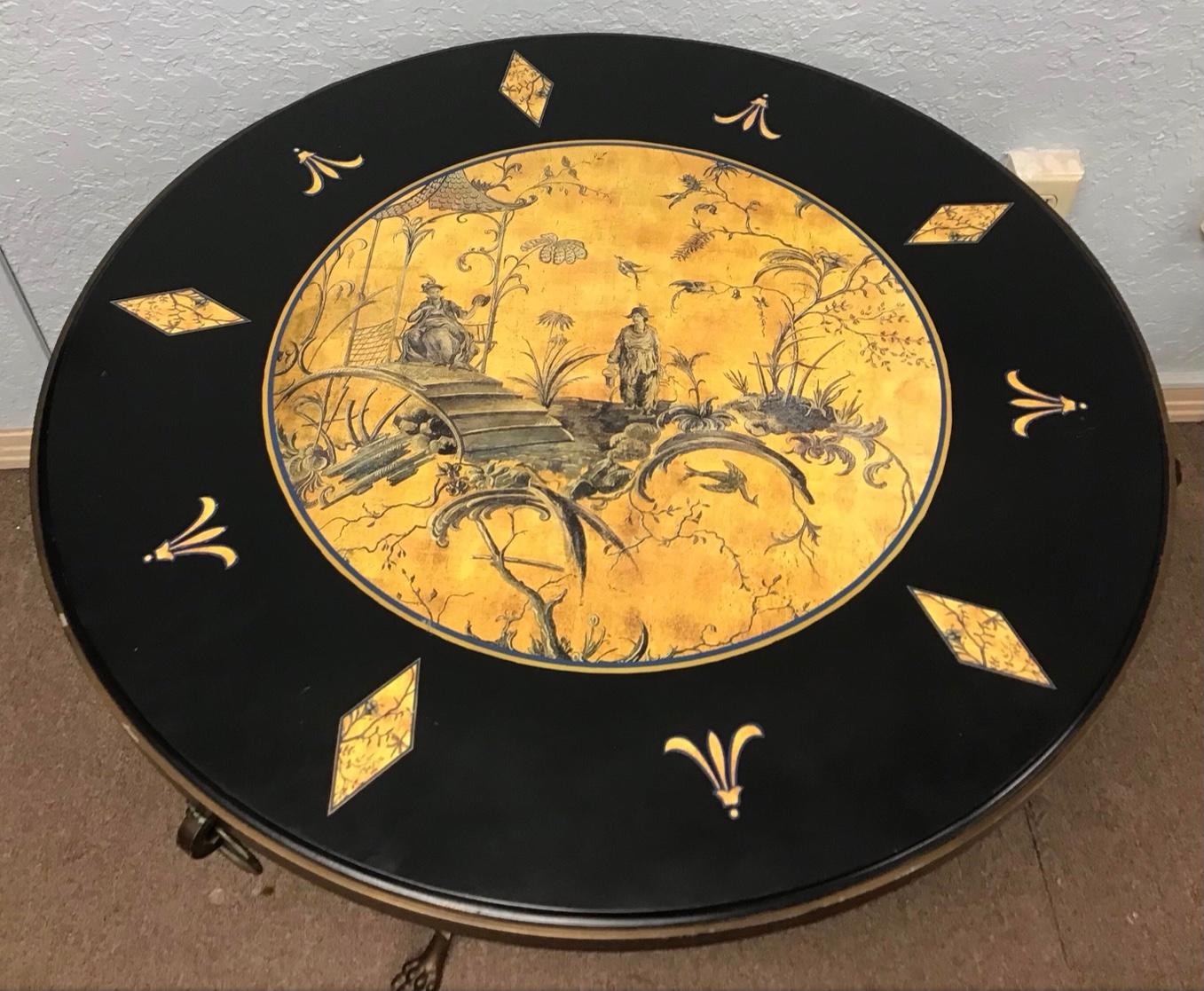 Sarreid brass entrance, side or center table. Decorated with Chinoiserie scenes and faux marble accents. The brass with three rings around the top and paw feet. Sarreid label attached to the bottom of the top.