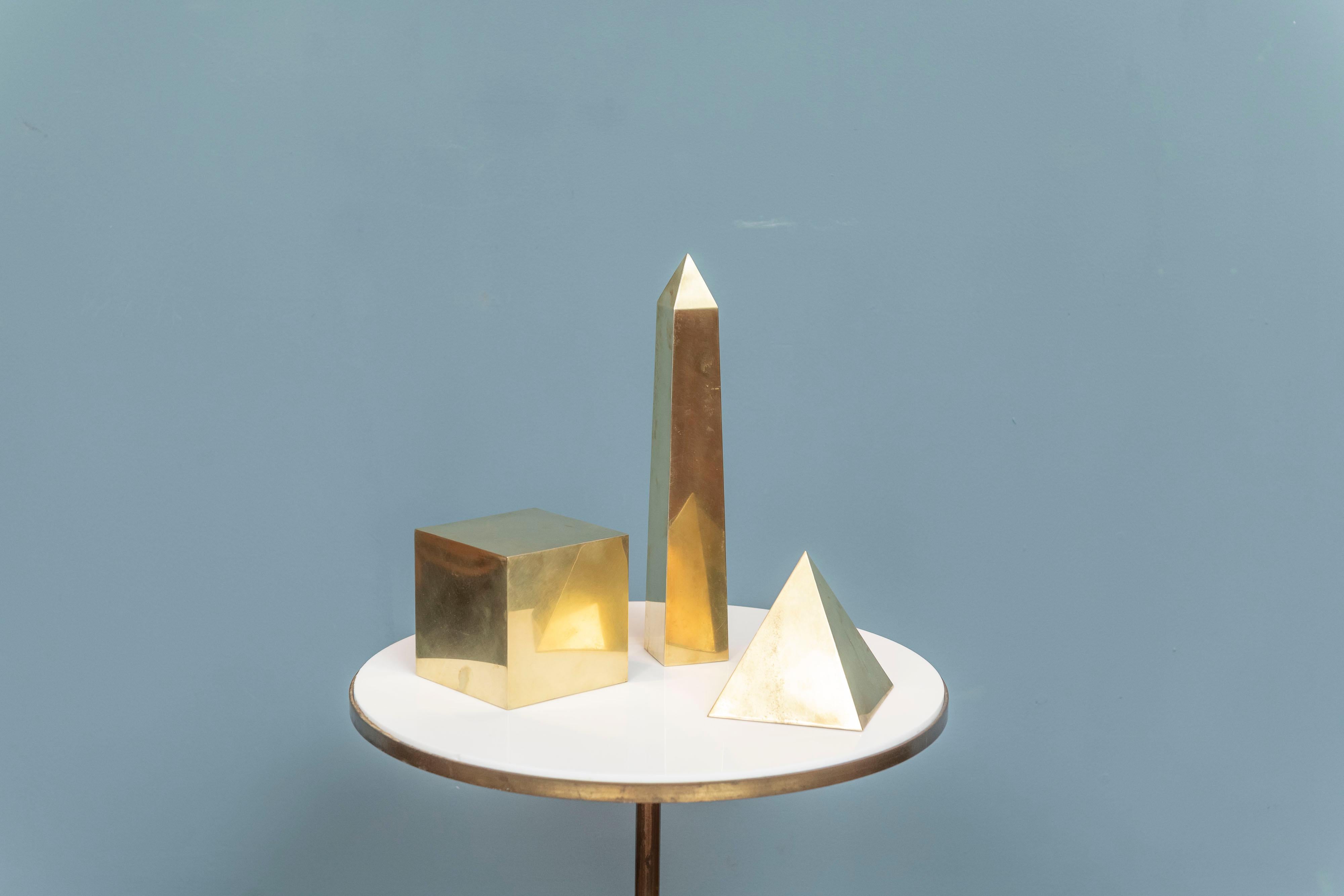 Sarried Ltd. design group of three brass classical table objects, Made in Italy. Interesting architectural models comprising a pyramid, obelisk and a square perfect for a coffee table or desk.

Measures: Obelisk 14.5