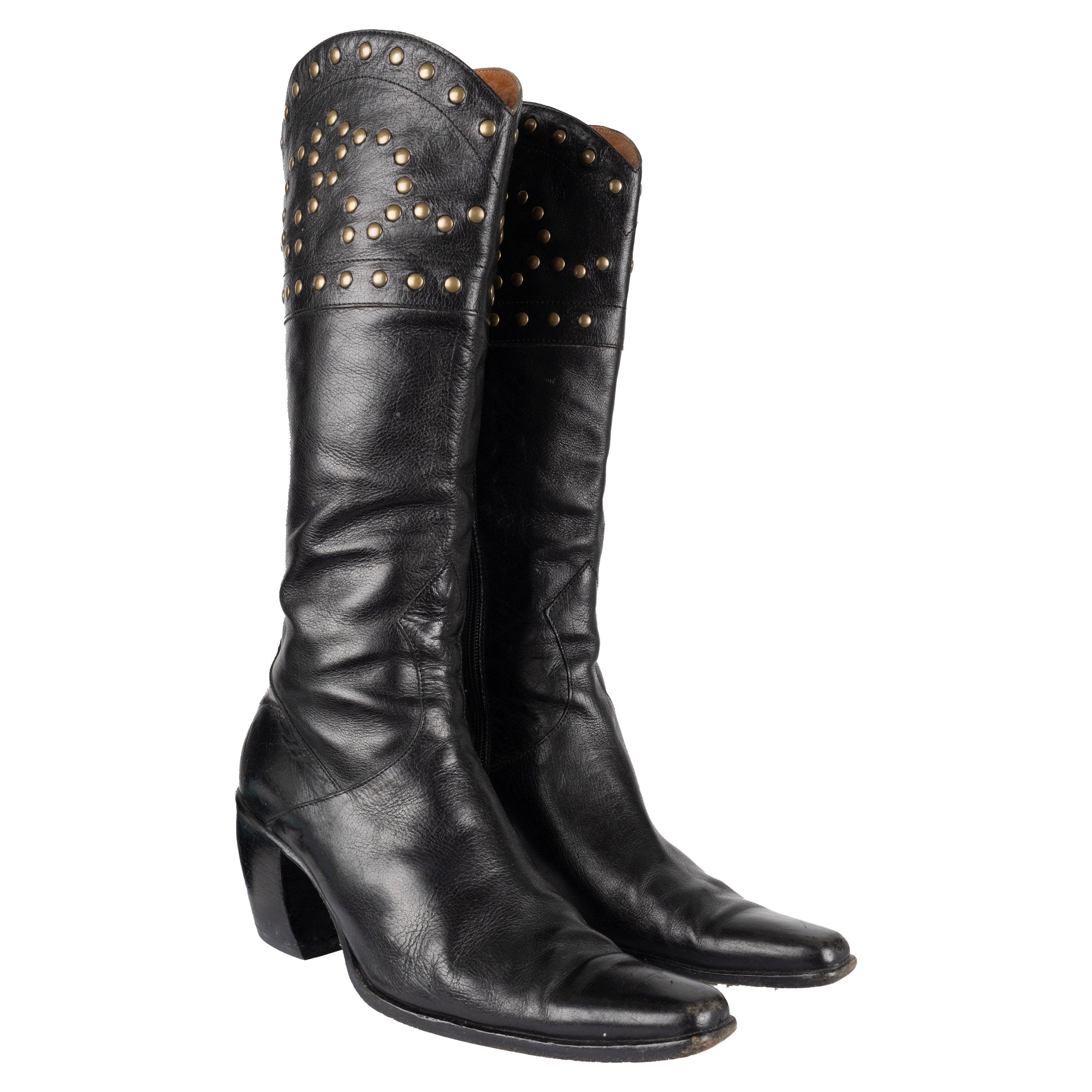 Estas botas Sartore Western con tachuelas están fabricadas en piel negra de primera calidad para un estilo clásico y sofisticado. La parte superior redondeada con tachuelas doradas añade un toque único, mientras que la puntera en punta y el tacón