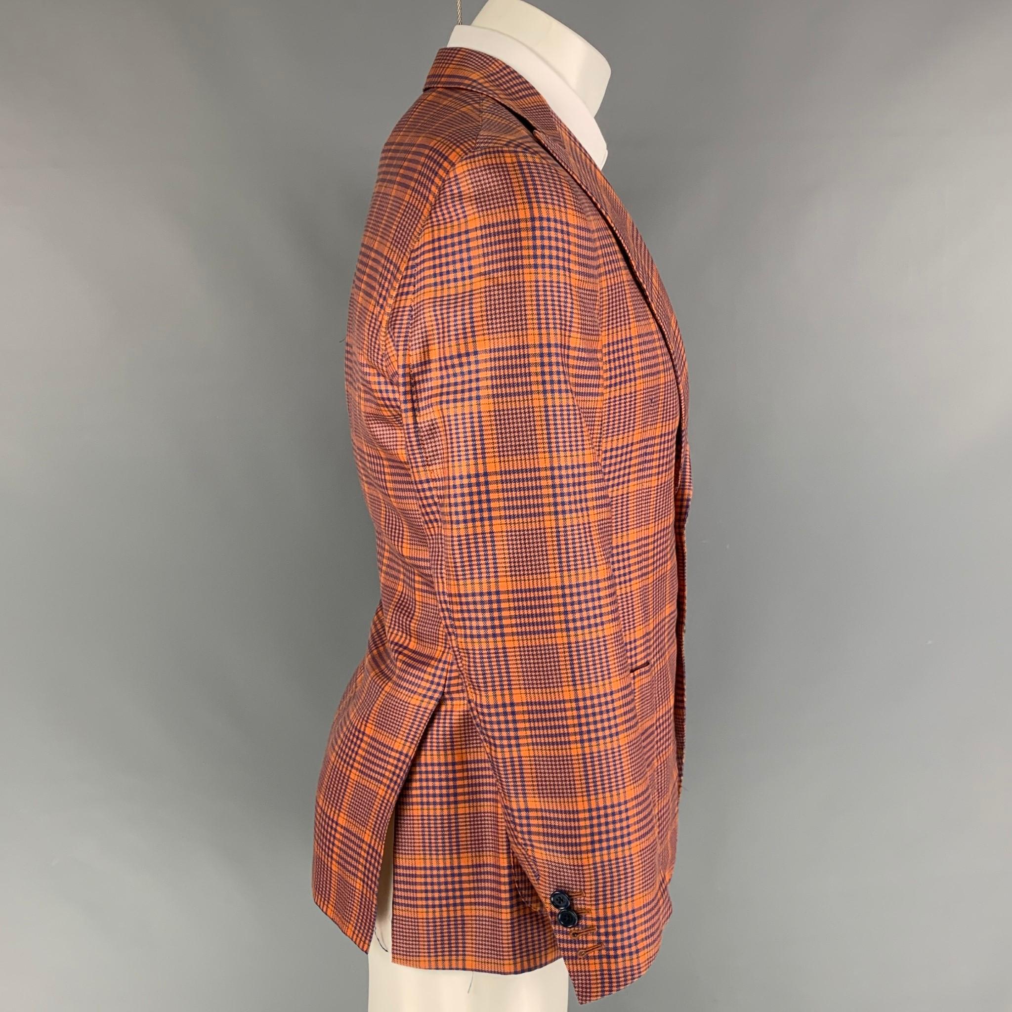 SARTORIA PARTENOPEA spot coat comes in a orange & blue houndstooth cashmere / silk with a full liner featuring a peak lapel, patch pockets, double back vent, and a double button closure. Made in Italy. 

Very Good Pre-Owned Condition.
Marked: Size