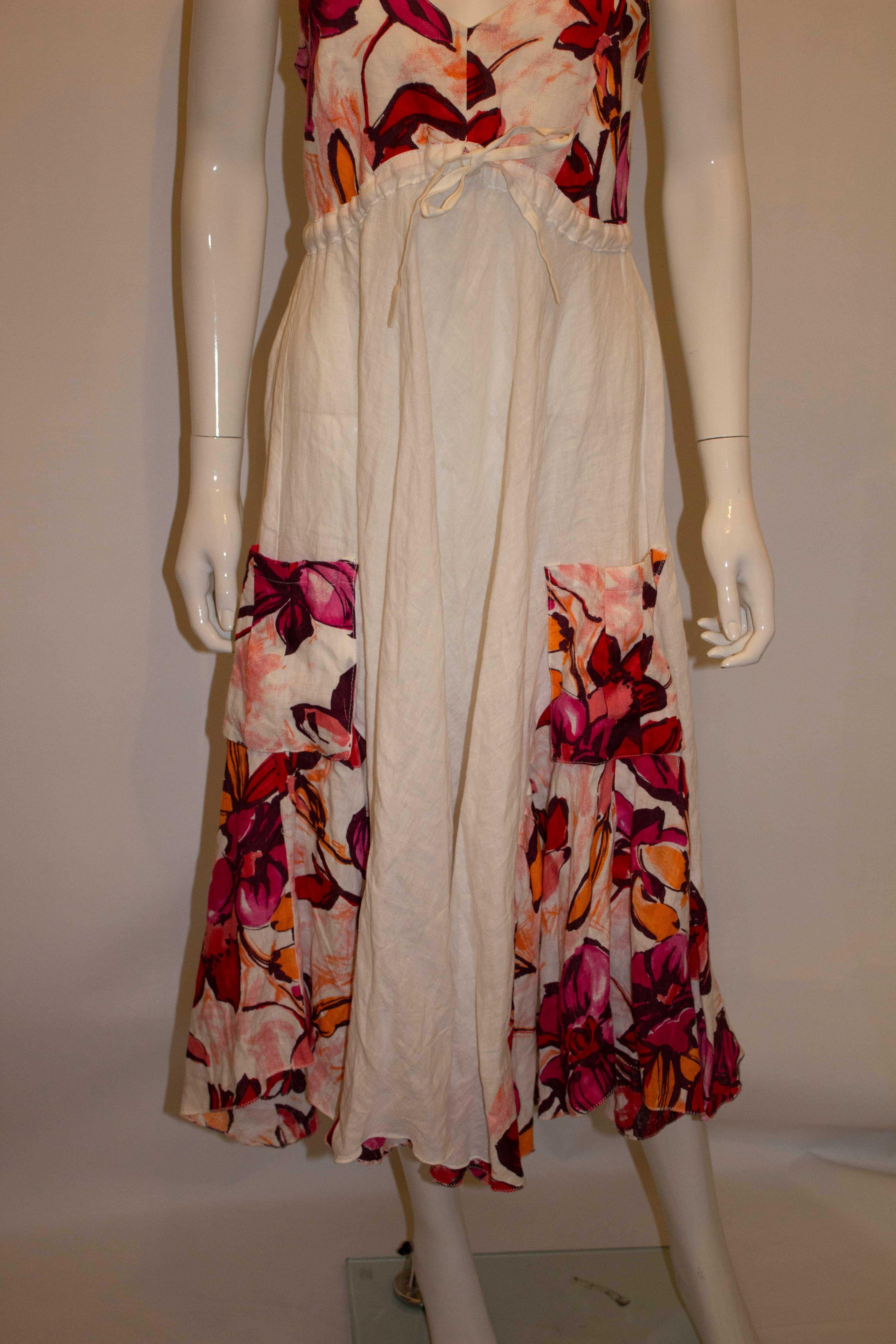 A pretty linen dress by Sartoria Saracena. The dress is in white linen with floral inserts. It has drawstring under the bust , elastic at the back and pockets on the front. 
Measurements: Bust 36'', length 48''
