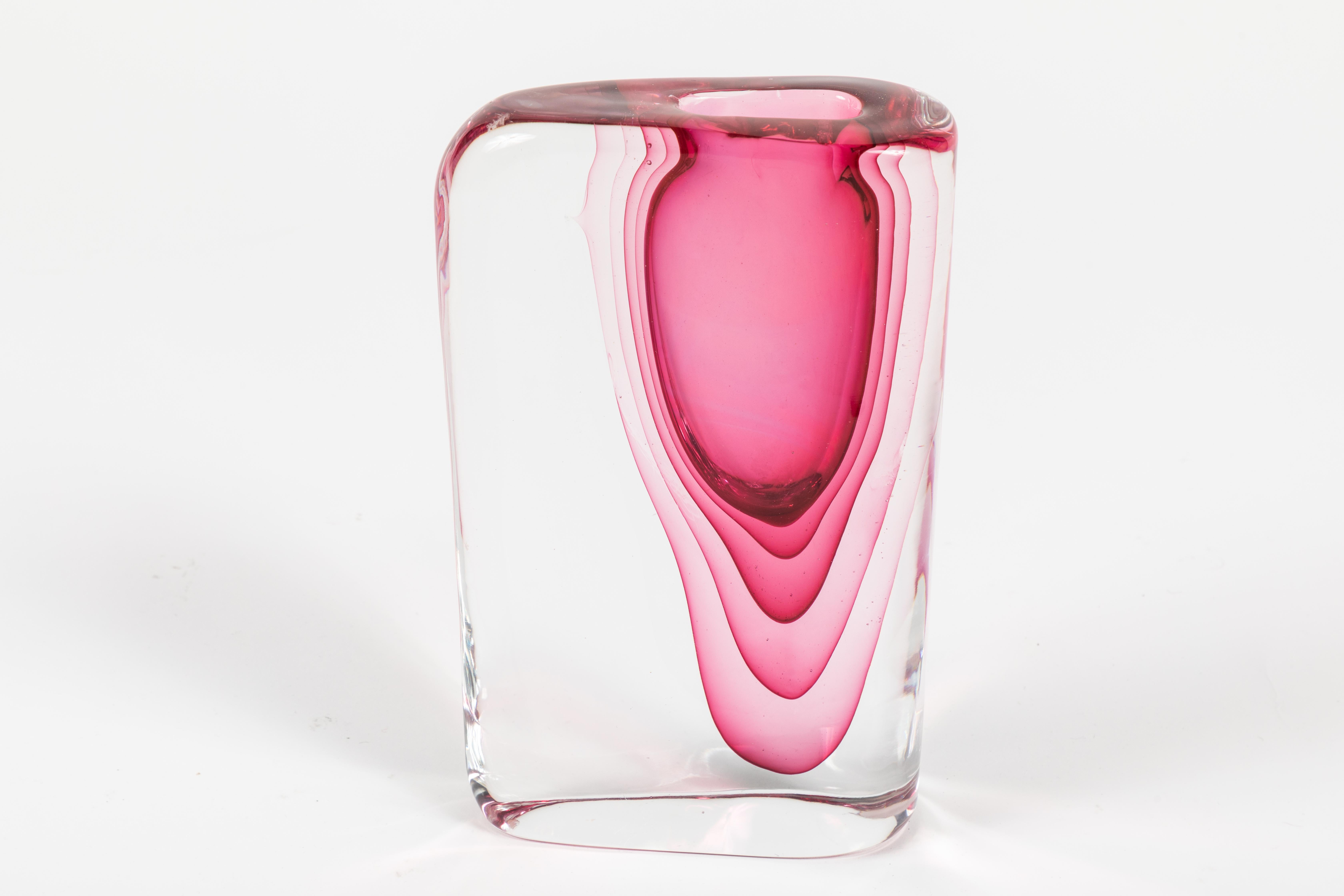 A vivid and striking Sasso Vase designed by Antonio da Ros and made by the Murano glass maker Chenedese. This vase exhibits the beautiful submersso technique this vase is know for. A deep cranberry pink/red color repeats in the body of the vase.