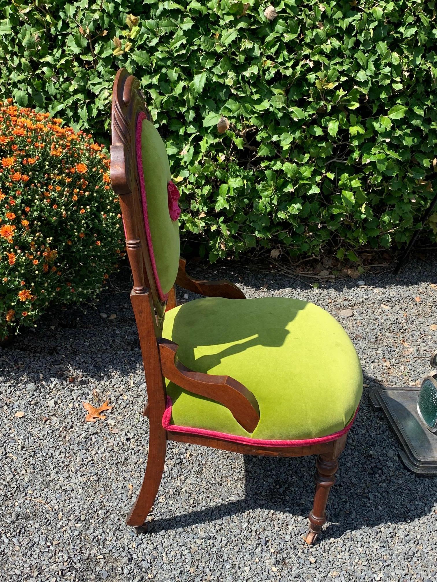 A stylish update of a carved wood Victorian chair upholstered imaginatively in bright chartreuse and magenta with a sassy little flower in the center of the back.