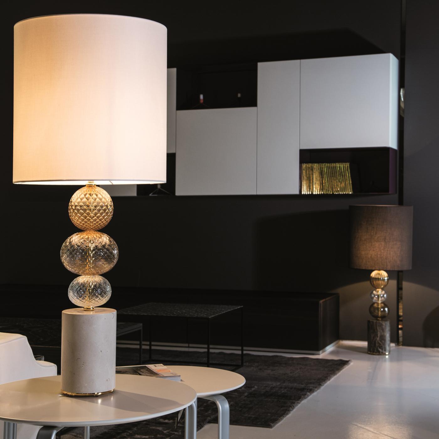 Part of the Satè Collection by Antonio Ventimiglia, this table lamp features a unique design of timeless sophistication that will enrich any room with soft, ambient light. Both the ivory fabric shade and the white marble base have a cylindrical