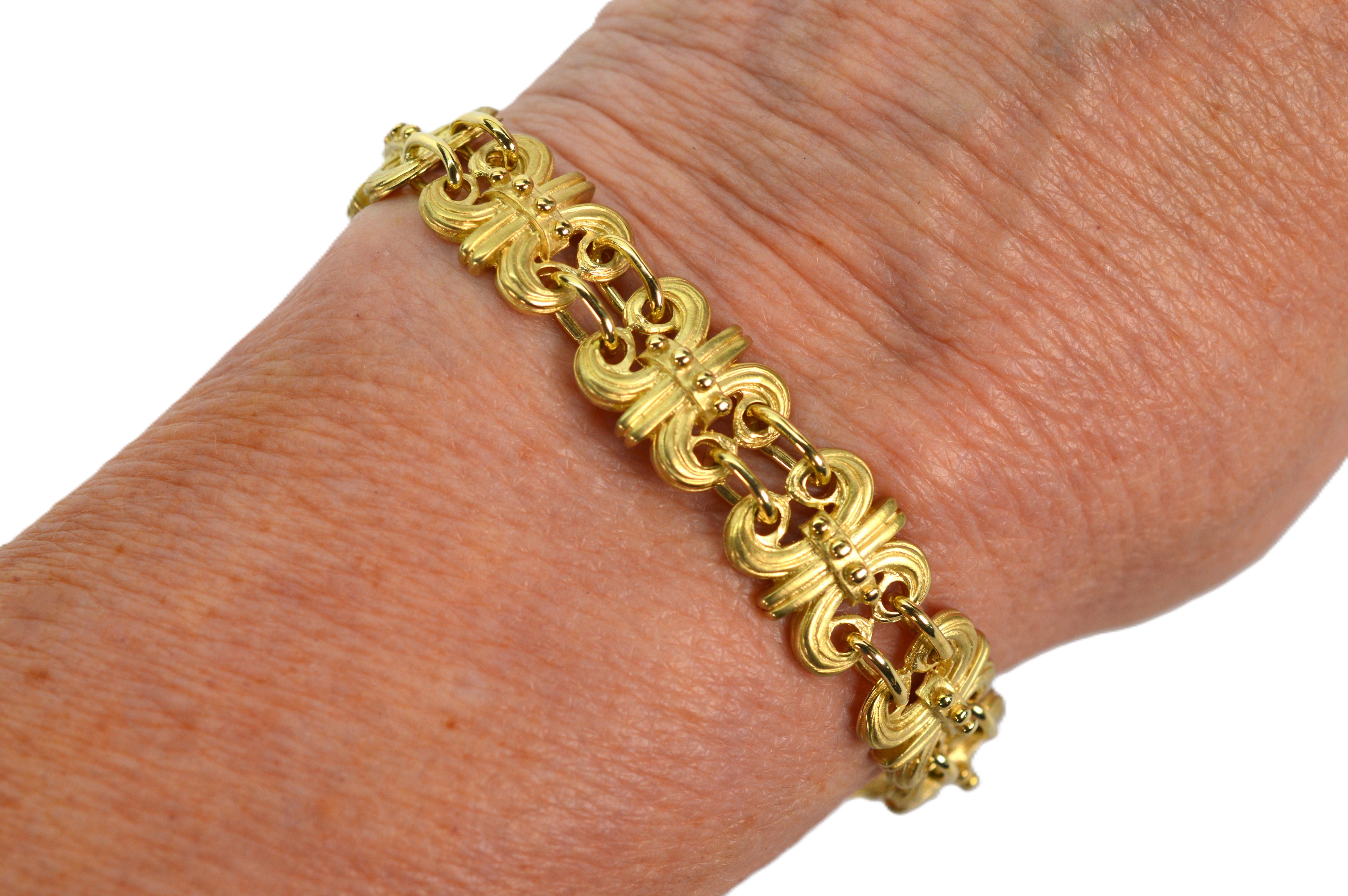 Un ensemble exquis, ce bracelet fleur de lis en or jaune 14k 18 carats satiné avec des accents en or poli brillant et des boucles d'oreilles assorties est d'une grande finesse. Terminé par un fermoir en forme de boîte, le bracelet à maillons mesure