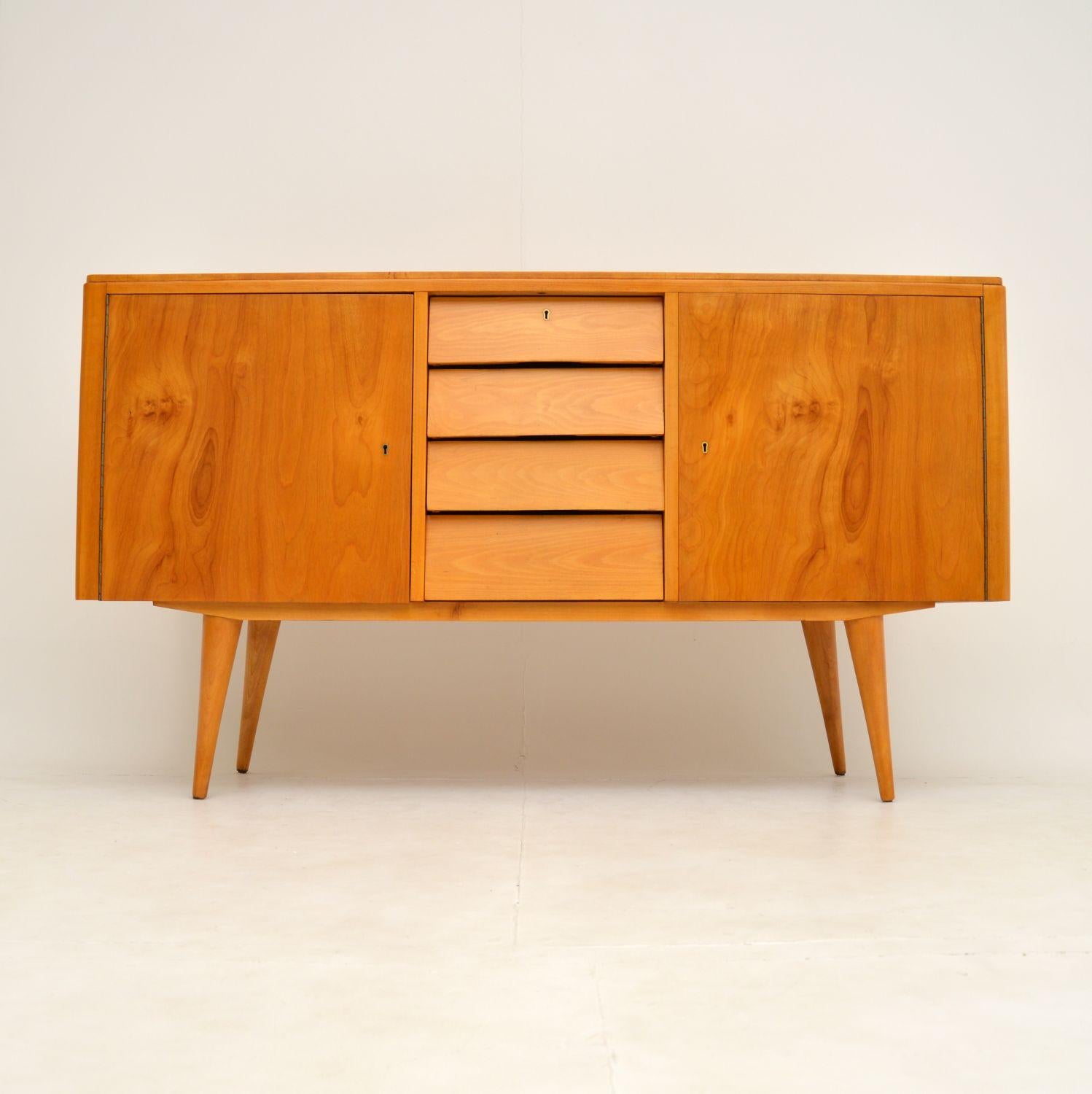 A stunning vintage sideboard, beautifully made from satin birch. This dates from the 1950’s, and was made in Britain.

This sideboard has a very interesting story and is well travelled. Originally purchased in England in the 1950’s, the previous