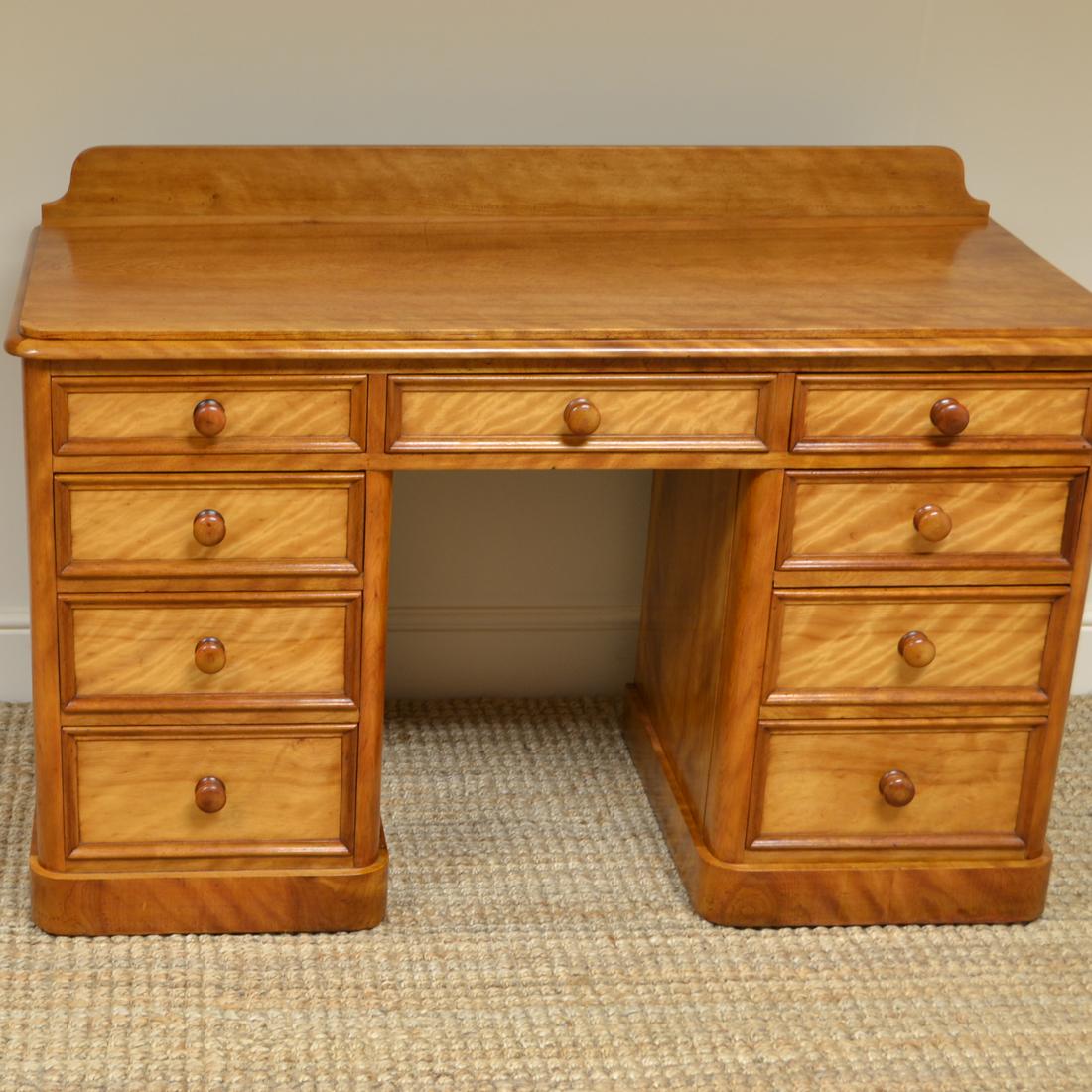 Unusual satin birch Victorian antique pedestal desk 
Dating from circa 1870 this Country House, unusual satin birch Victorian antique pedestal desk has a raised back above a moulded top with central drawer over kneehole. Each pedestal has four