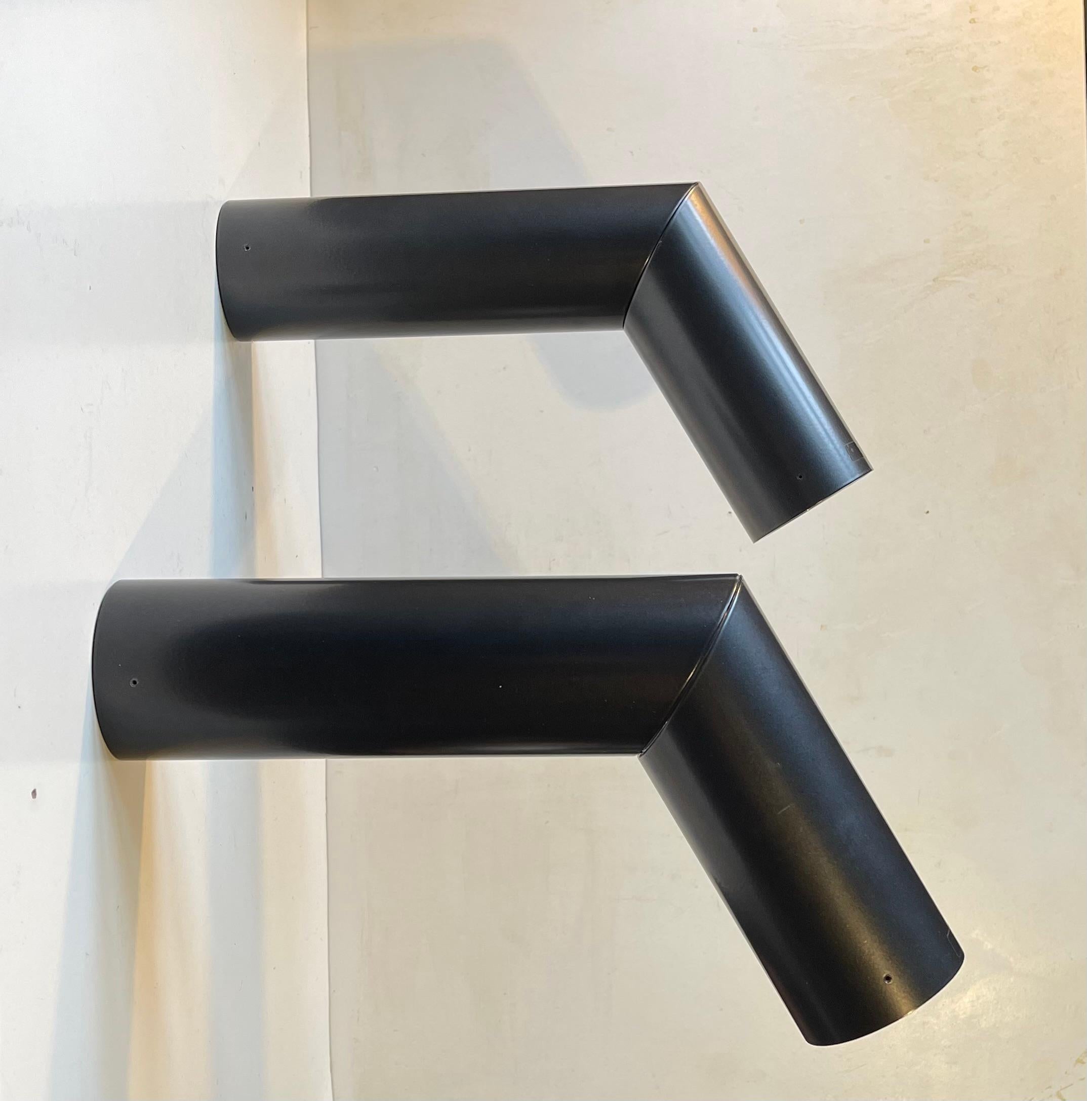 E06 is in a family of adjustable tubular luminaires with a cylindrical lamp body. Here a set in satin black. Designed by Habits Studio in 2008 and produced by the famous Luceplan brand. They feature a cylindrical body in extruded aluminum. It has