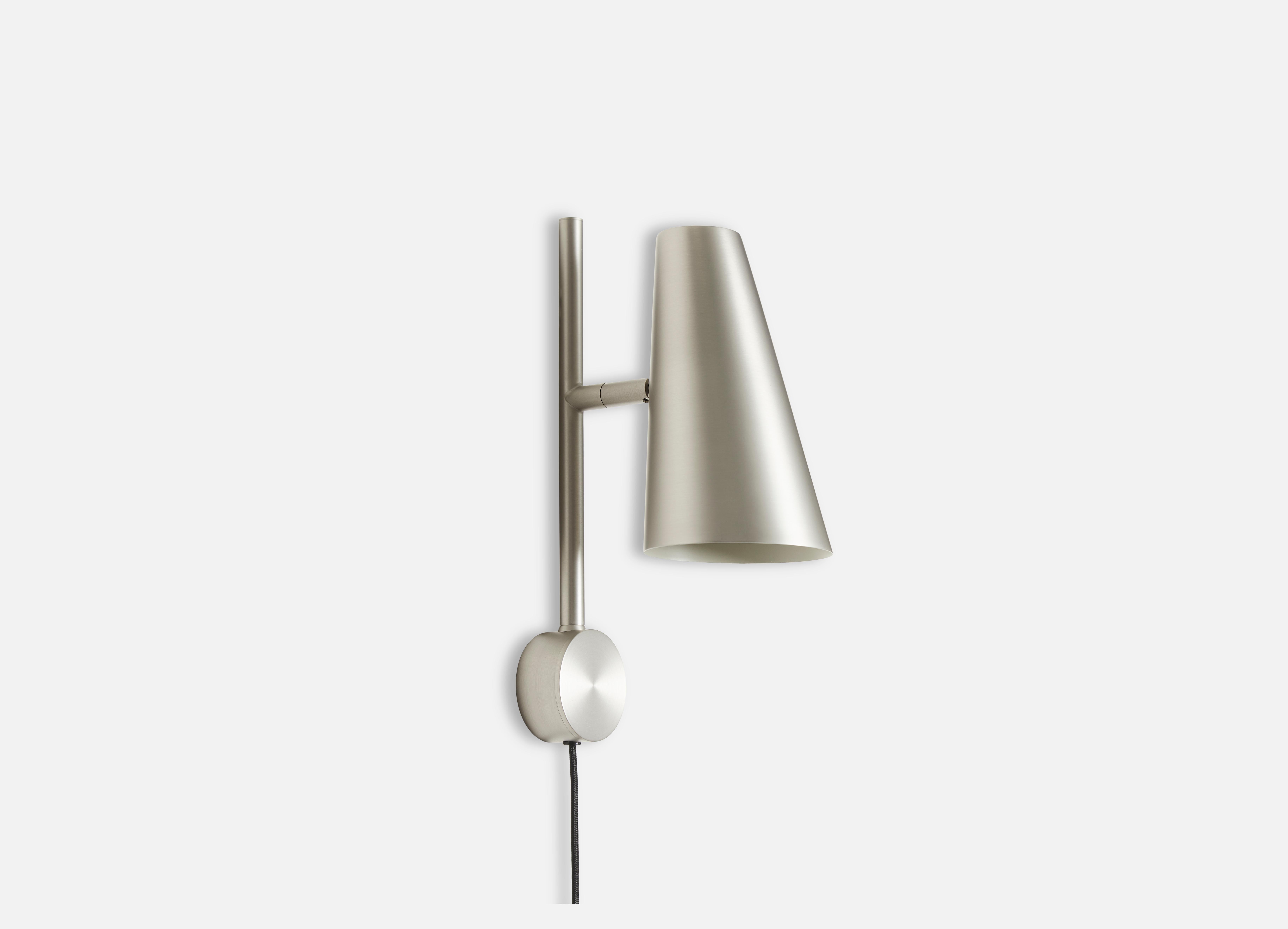 Satin Cono wall lamp by Benny Frandsen.
Materials: metal.
Dimensions: D 11 x W 17 x H 33.3 cm.
Available in black or satin.

Benny Frandsen is a renowned and experienced danish designer and founder of the lighting company frandsen, which has