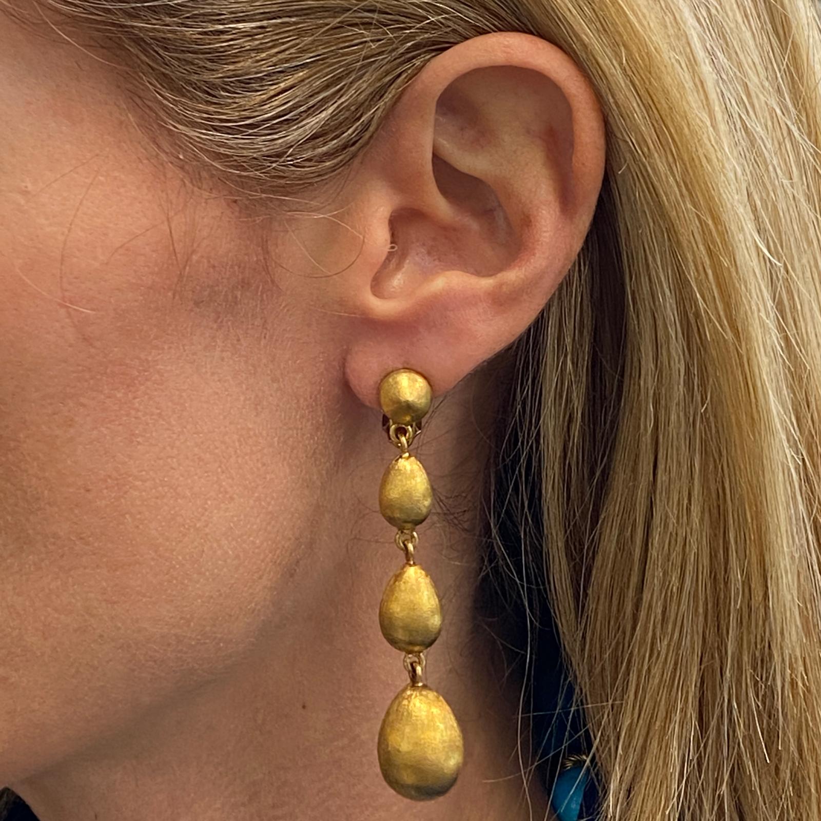 Beautiful drop earrings fashioned in satin finished 18 karat yellow gold. The earrings measure 2.75 inches in length and feature leverbacks. 