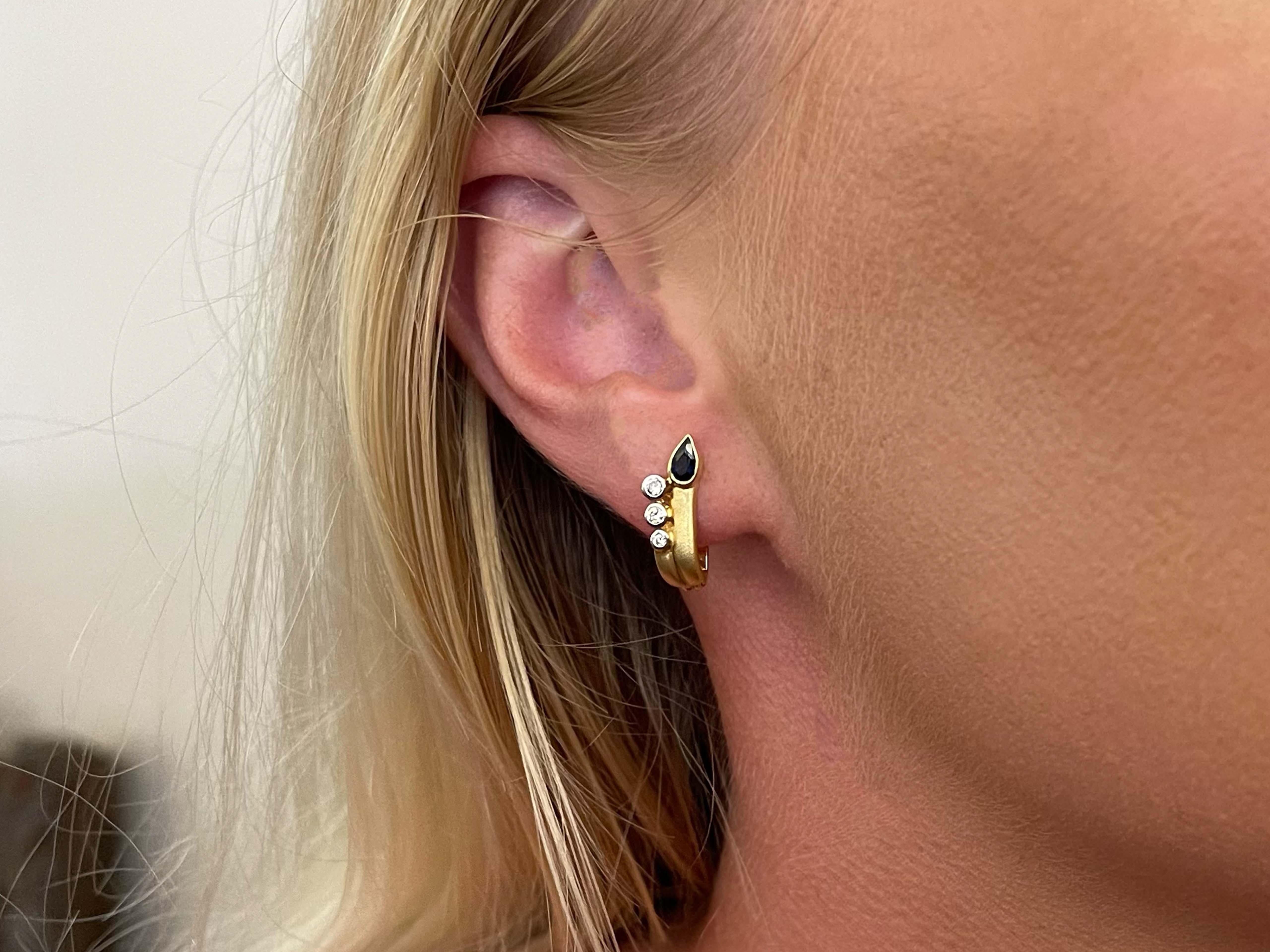 Earrings Specifications:

Metal: 18k Yellow Gold

Earring Length: 18 mm

Total Weight: 4.2 Grams
​
​Gemstone: blue sapphire
​
​Sapphire Carat Weight: ~0.20 carats

Diamonds: 6

Diamond Color: J-K

Diamond Clarity: VS

Condition: Preowned

Stamped: