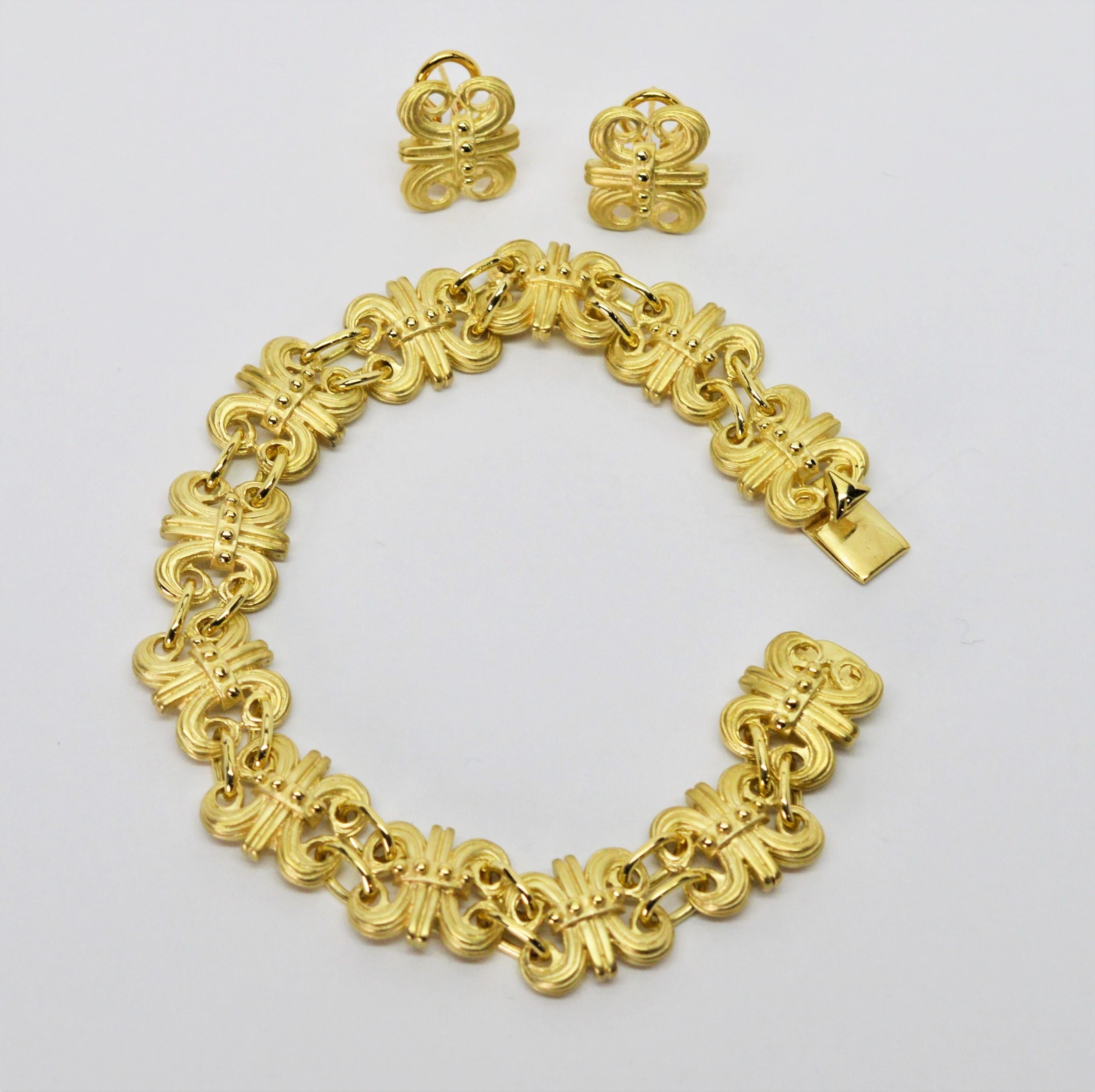 Un ensemble exquis, ce bracelet fleur de lis en or jaune 14k 18 carats satiné avec des accents en or poli brillant et des boucles d'oreilles assorties est d'une grande finesse. Terminé par un fermoir en forme de boîte, le bracelet à maillons mesure