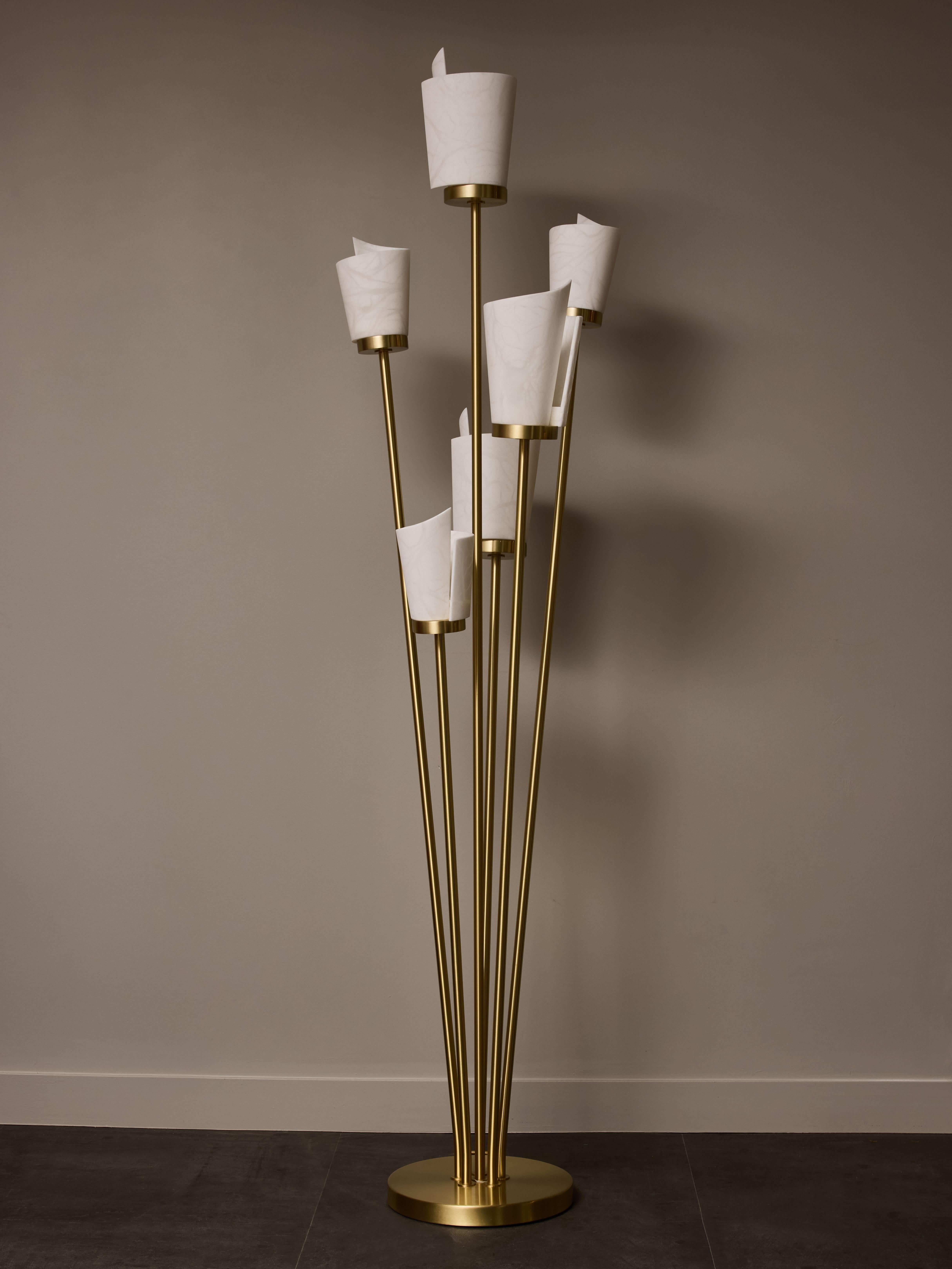 Lampada da terra in ottone satinato composta da una base rotonda e sei bracci di luce inclinati sormontati da un nuovo diffusore a spirale in alabastro.

