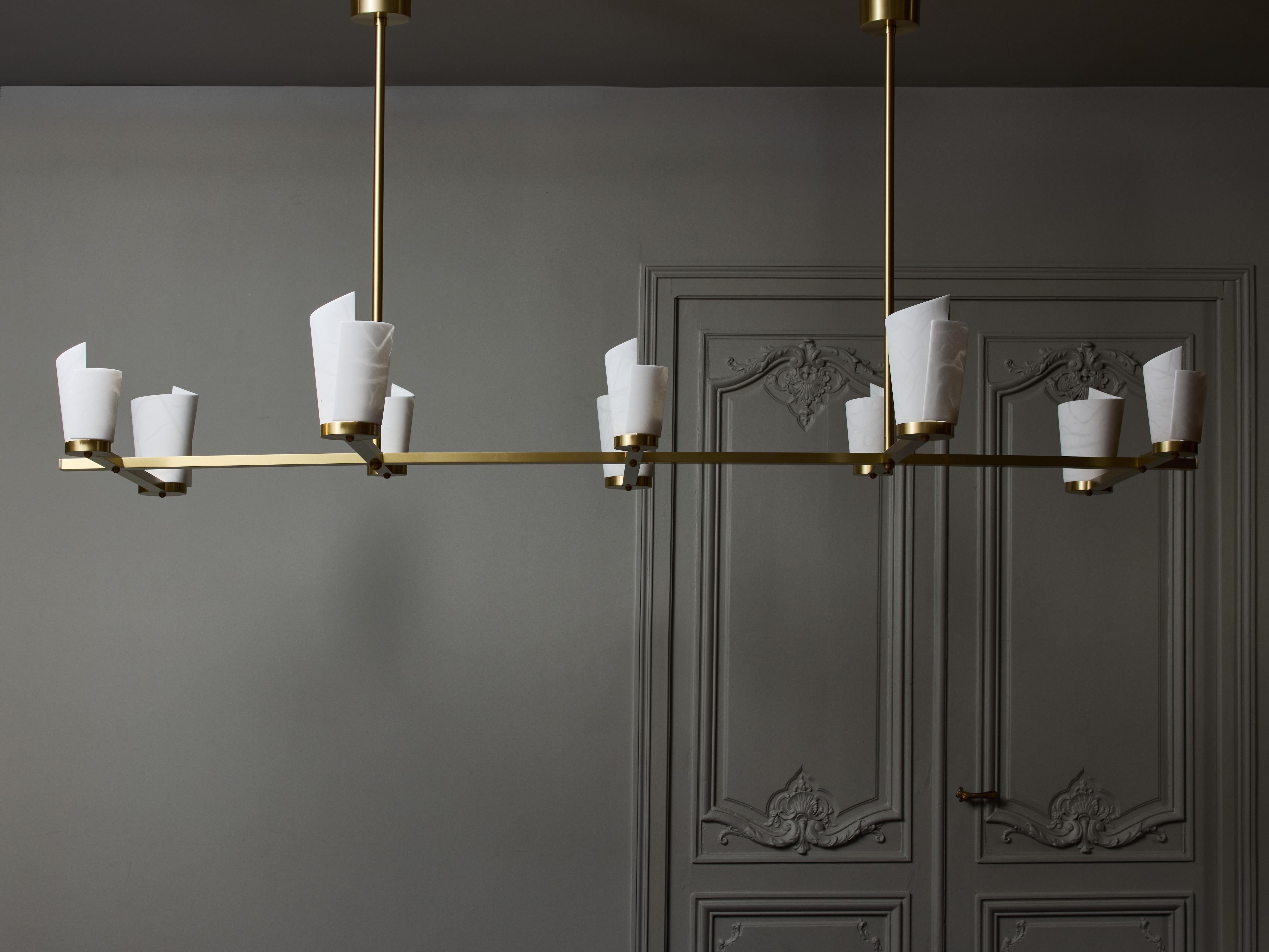 Long chandelier made of satinated brass with new spiral shaped alabaster diffusers.

the two sized arms are alternated on the structure for a symetrical look. 