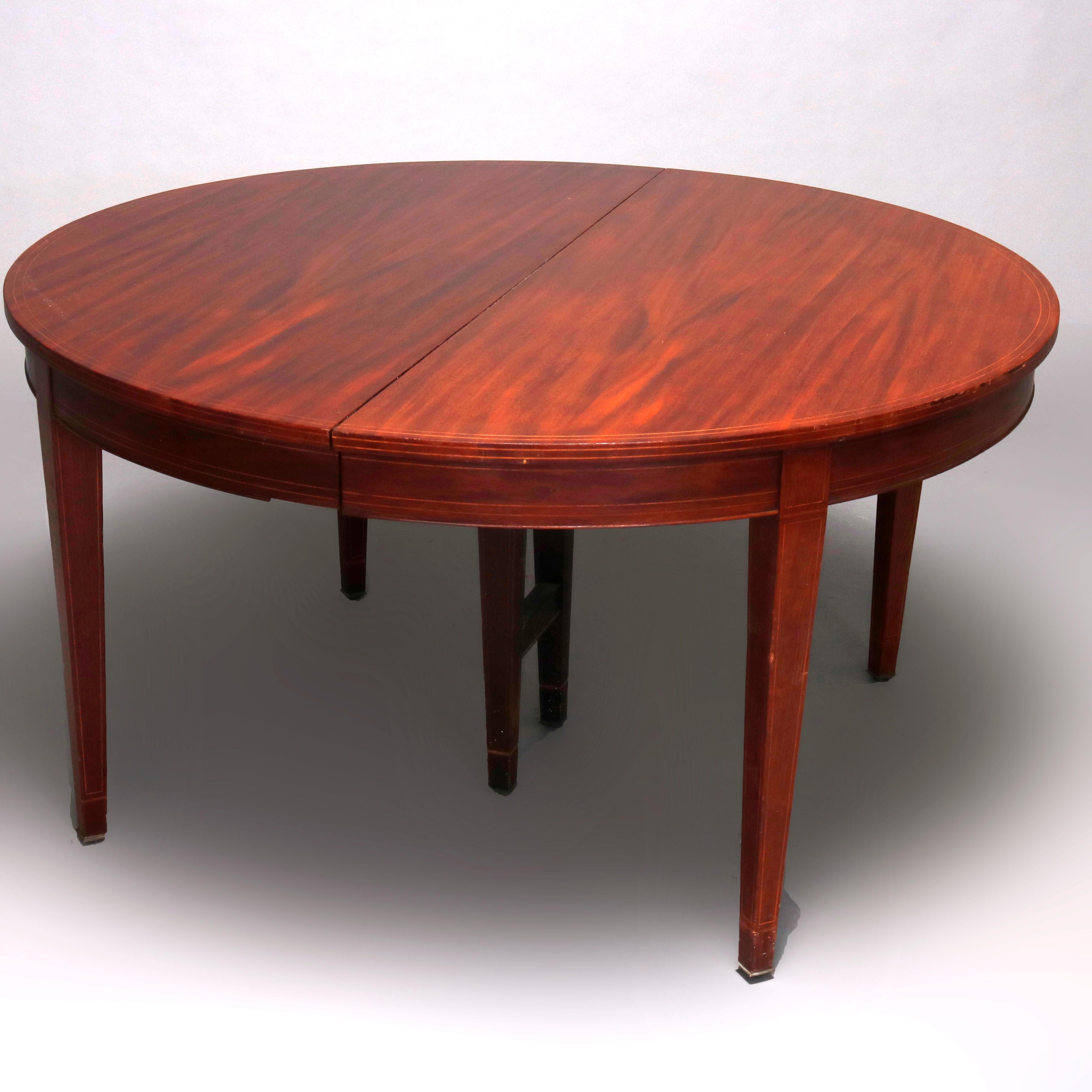 A vintage Hepplewhite style extension banquet table offers oval form in mahogany construction with satinwood banding and raised on square and tapered legs, with six leaves, c1930

***DELIVERY NOTICE – Due to COVID-19 we are employing NO-CONTACT