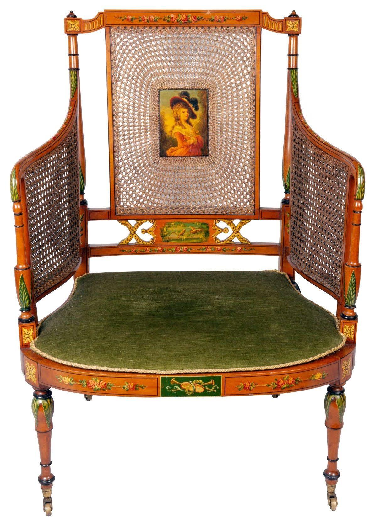 A very good quality late 19th Century Satinwood bergere library arm chair, having cane sides and back rest, with an inset hand-painted panel depicting a lady wearing a hat, floral decoration and inset painted panels.a cushion seat and raised on