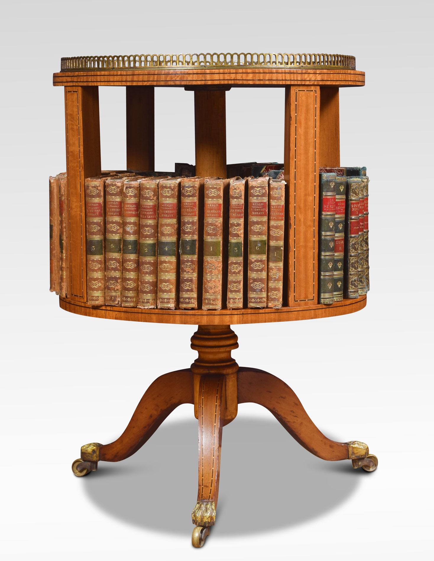 Edwardian satinwood and string inlaid revolving bookcase with circular top and raised pierced brass gallery above book divisions supported on a ring turned stem and down swept legs, fitted with brass paw feet and casters.
Dimensions
Height 26.5