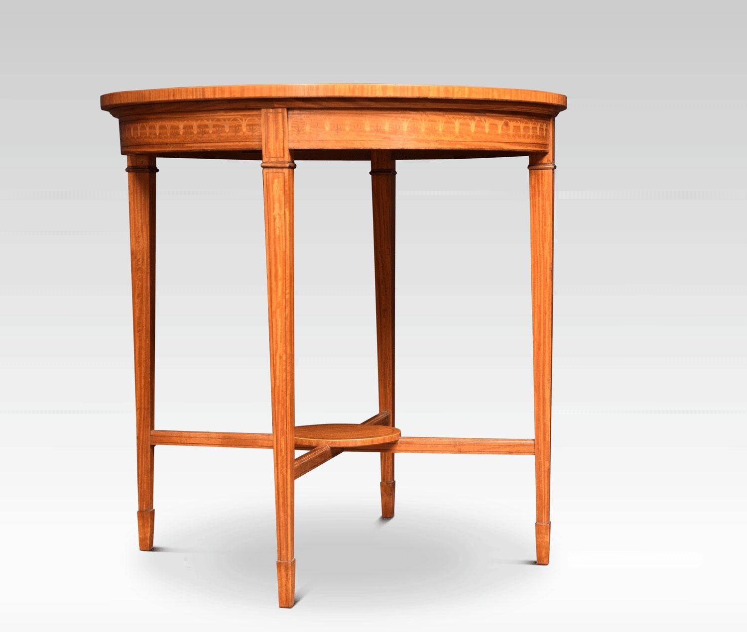 Table centrale édouardienne en bois de satin marqueté, le plateau circulaire à bandes croisées est centré par un motif de tête de fleur en buis et bois dur, dans une guirlande de houppes. Le tout reposant sur quatre pieds carrés effilés terminés par